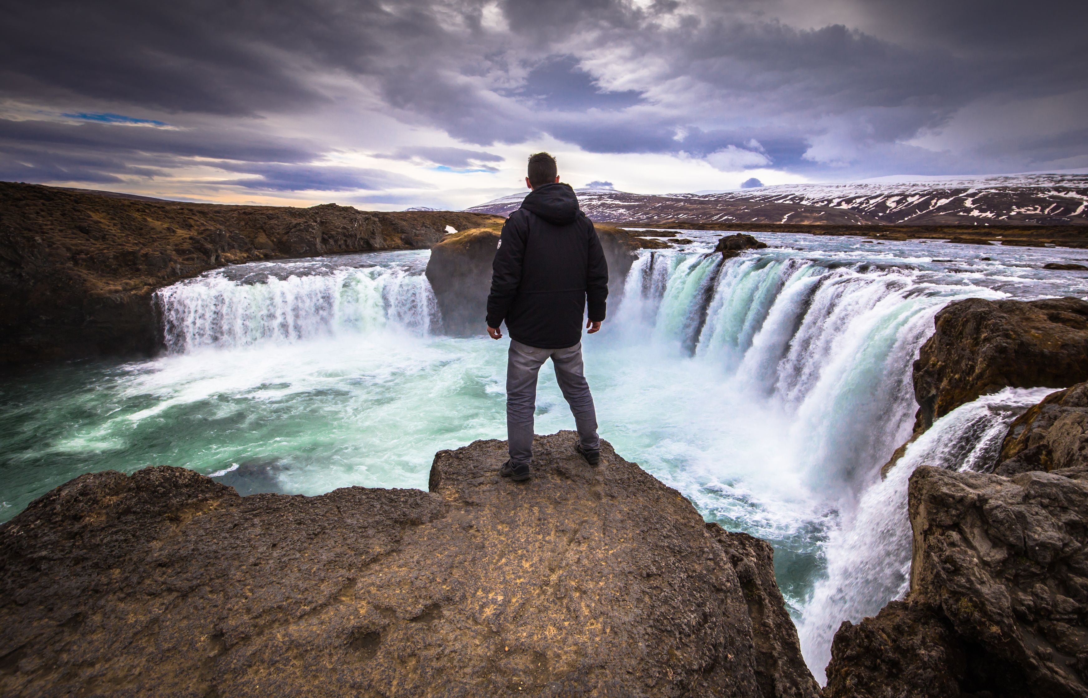 Man admiring Godafoss Waterfall in May