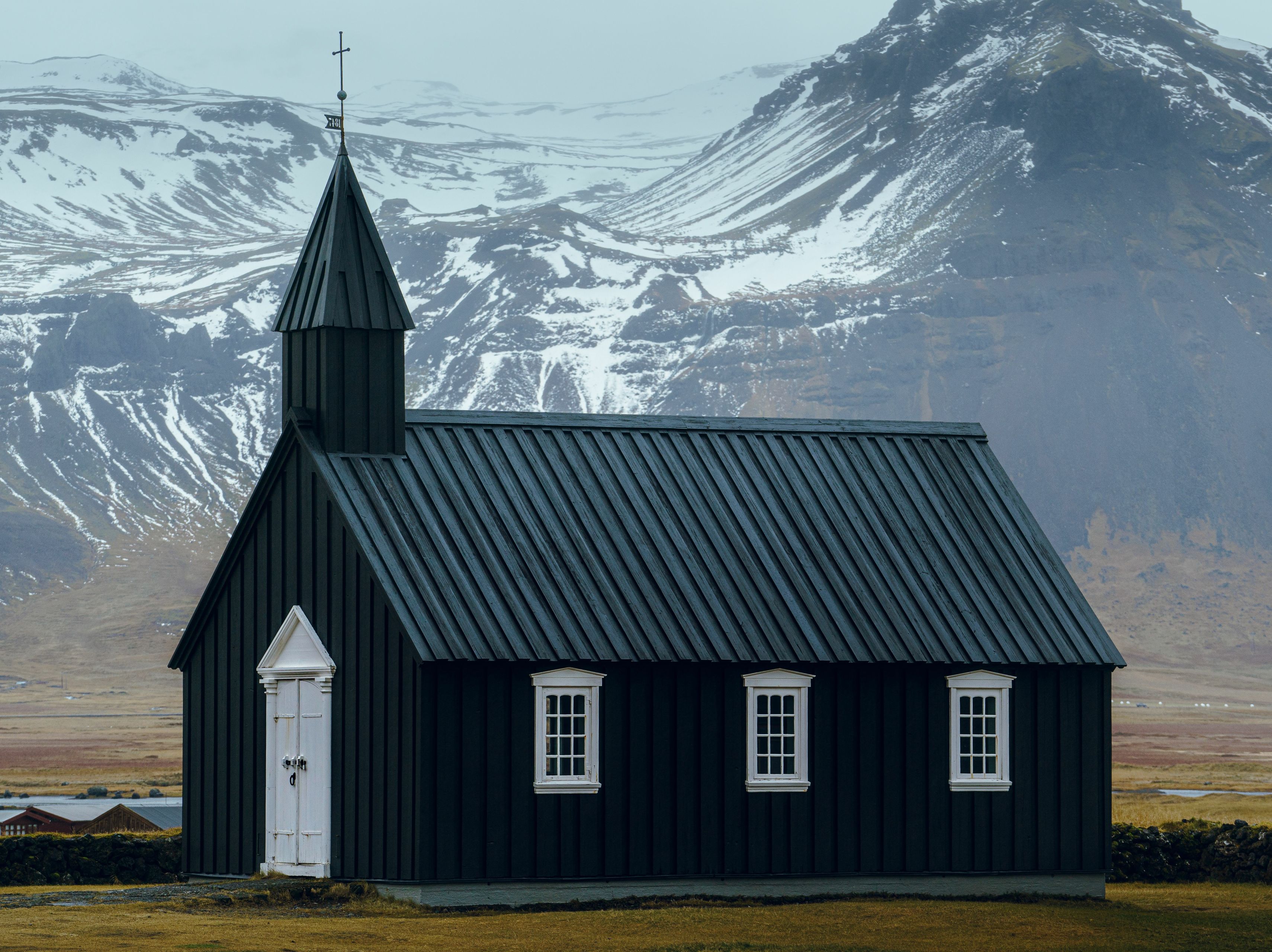 View on the Budir black church and the snowy mountains in the background  