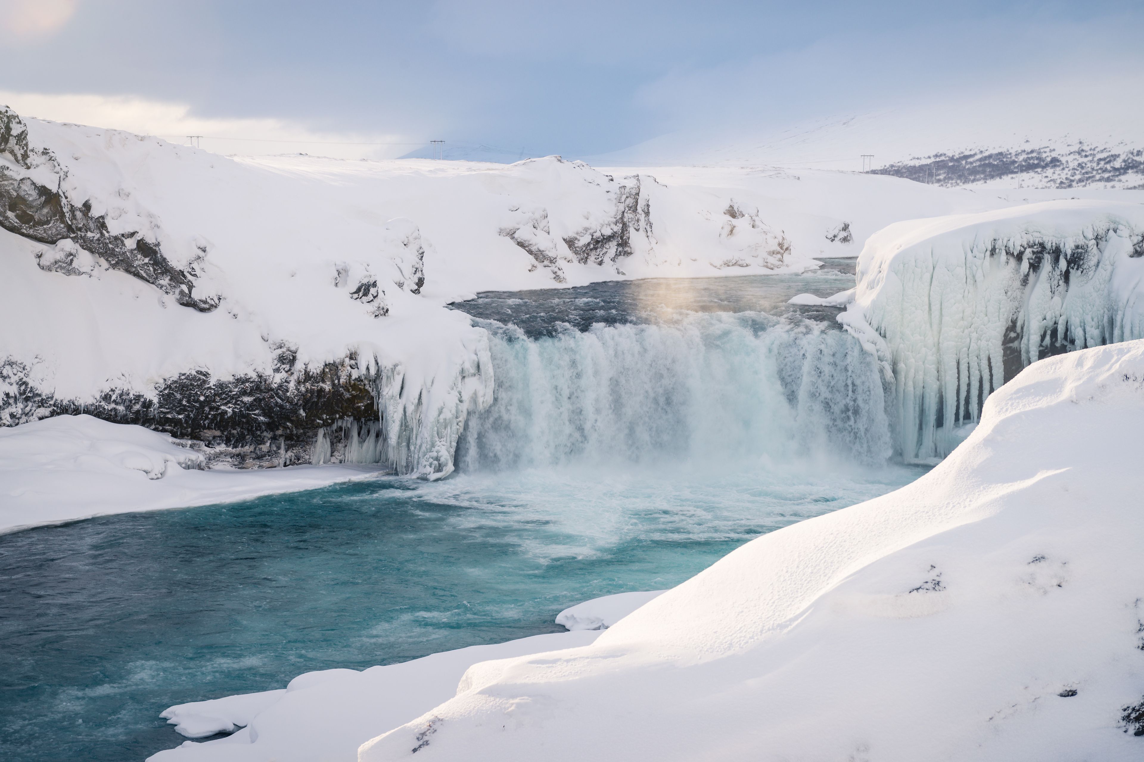 Ein Bild des Godafoss-Wasserfalls mit Schnee an einem warmen Tag. Erstaunliche Erfahrung für jeden, der nach Island kommt.