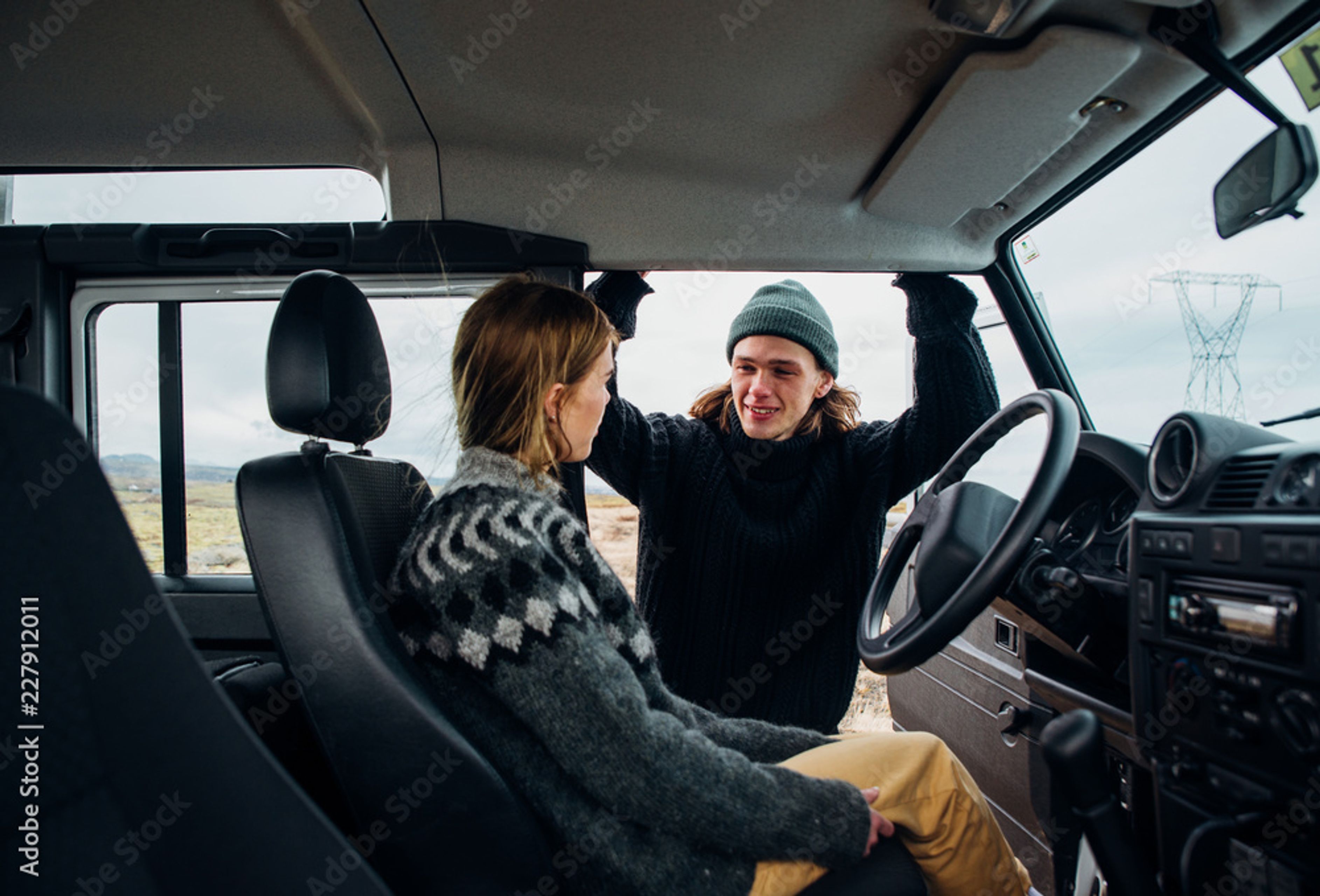 Two people in a car in Iceland, wearing winter clothes