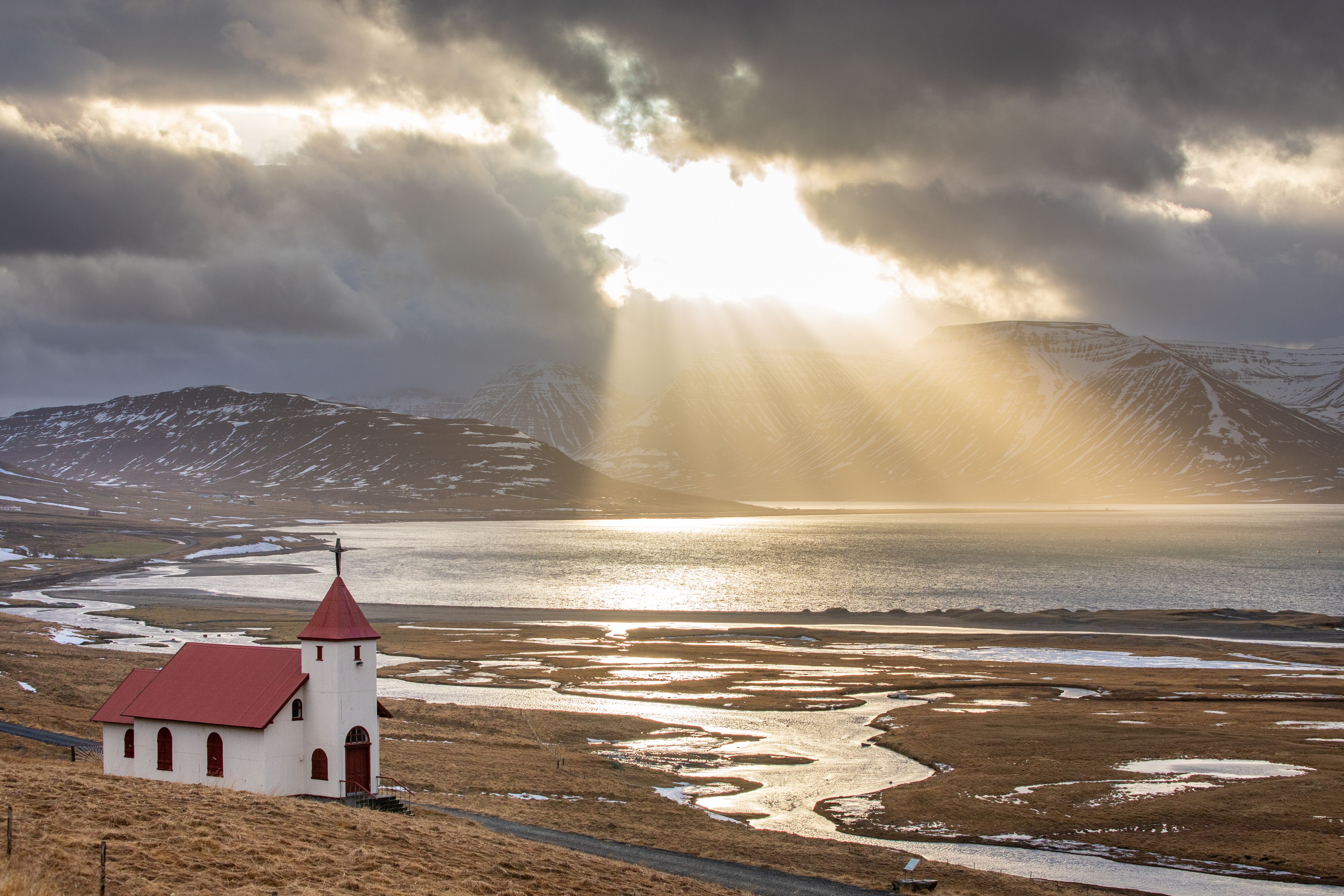 Iglesia junto a un lago al que le da el sol en Islandia