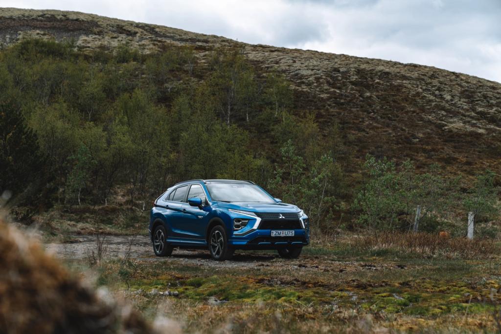A Blue Mitsubishi Eclipse Cross parked near trees