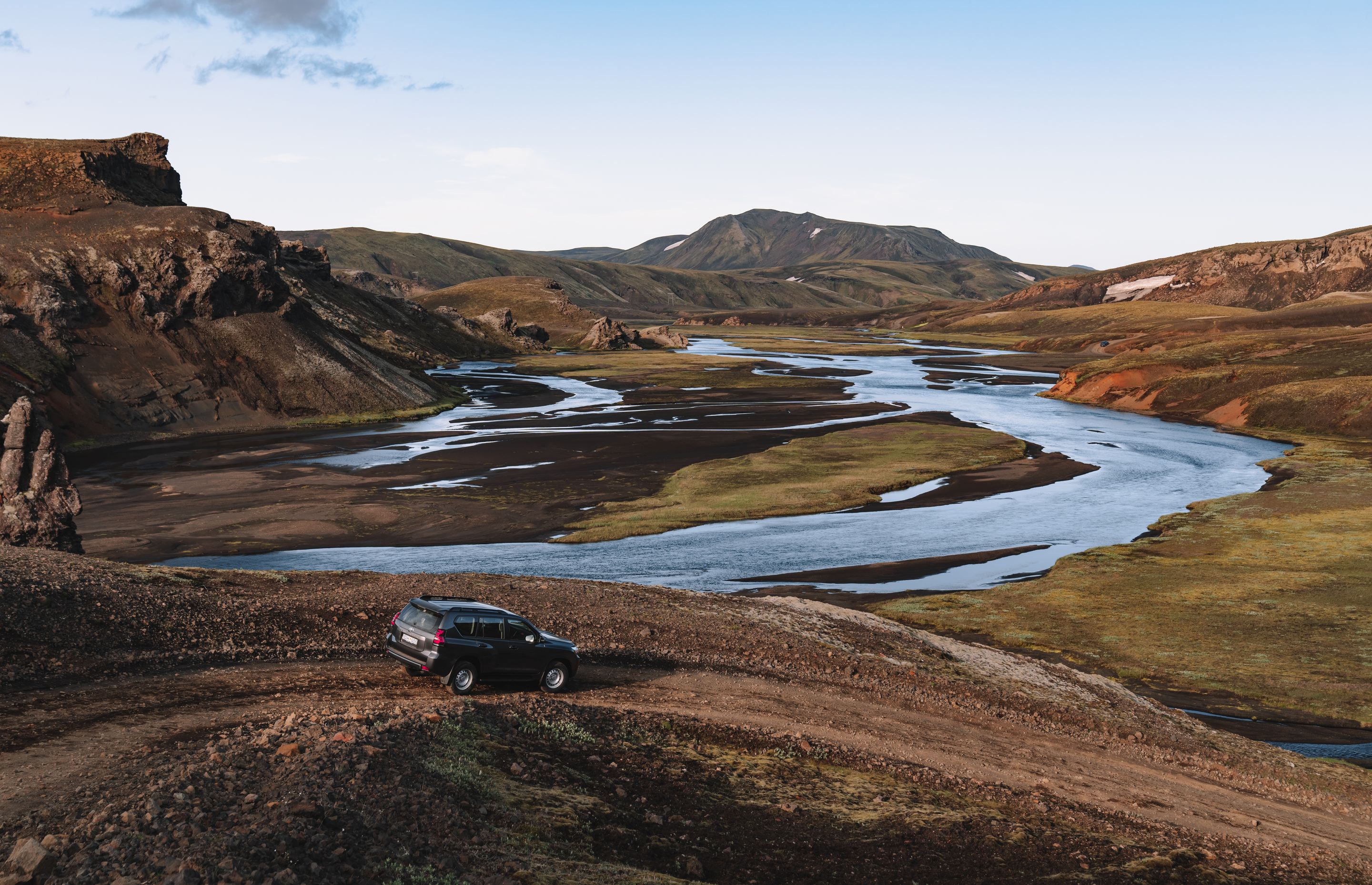 A Toyota Land Cruiser from Go Car Rental parked in Iceland with a captivating landscape backdrop featuring black sand beaches and the country's unique tectonic plates.