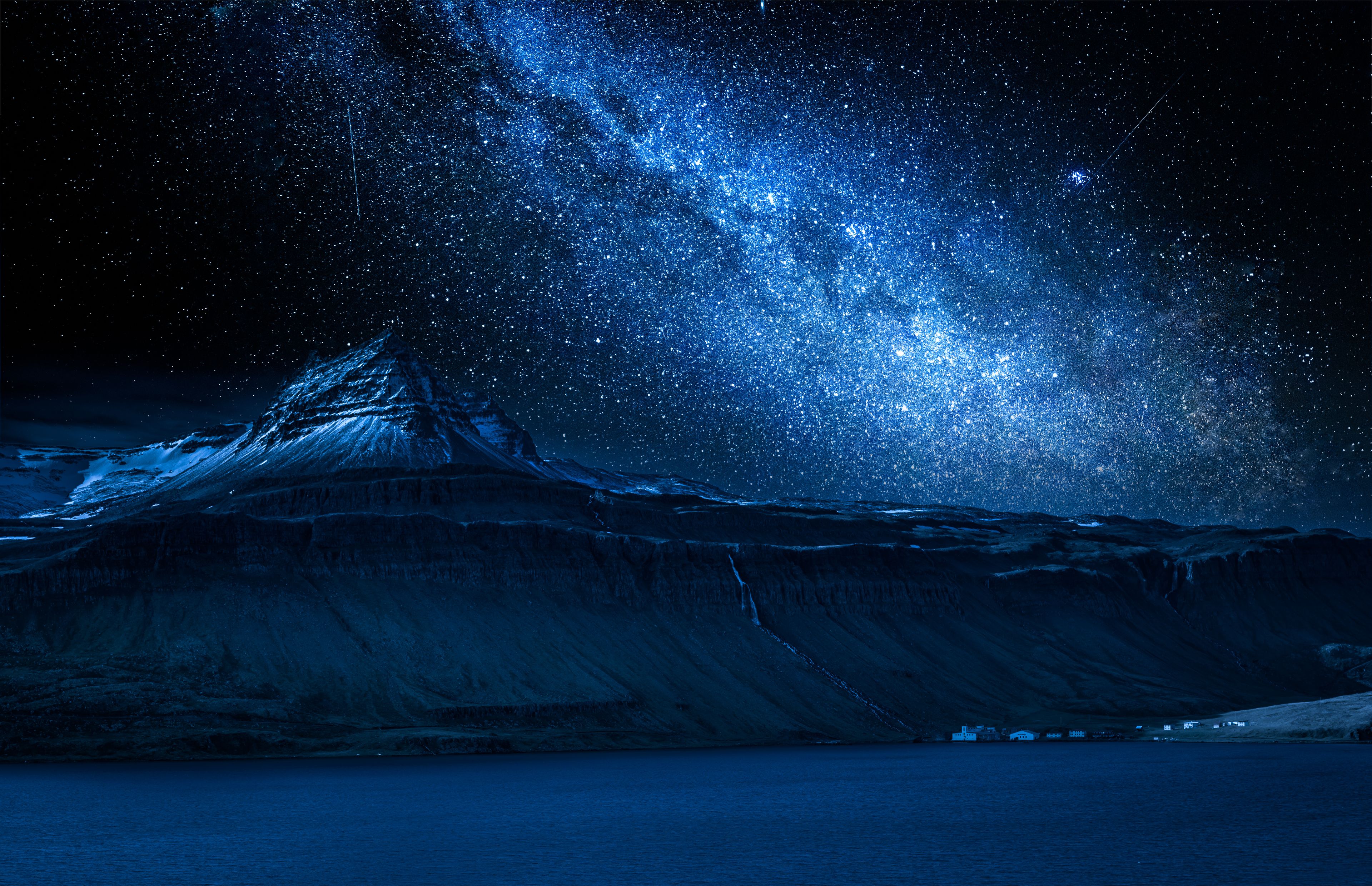 Vía Láctea y montaña volcánica sobre un fiordo en la noche, Islandia