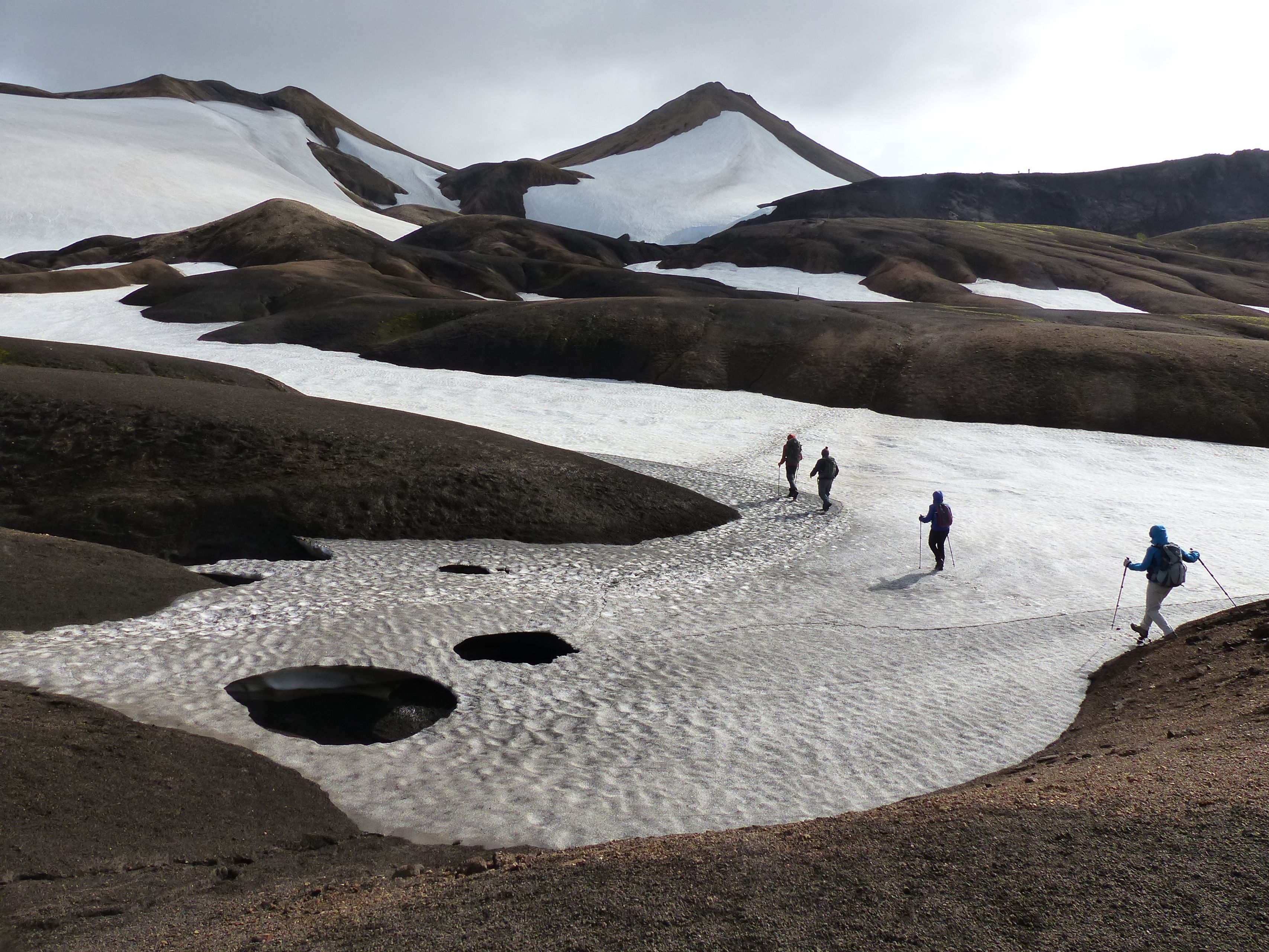 People hiking through a small glacier in Thórsmörk