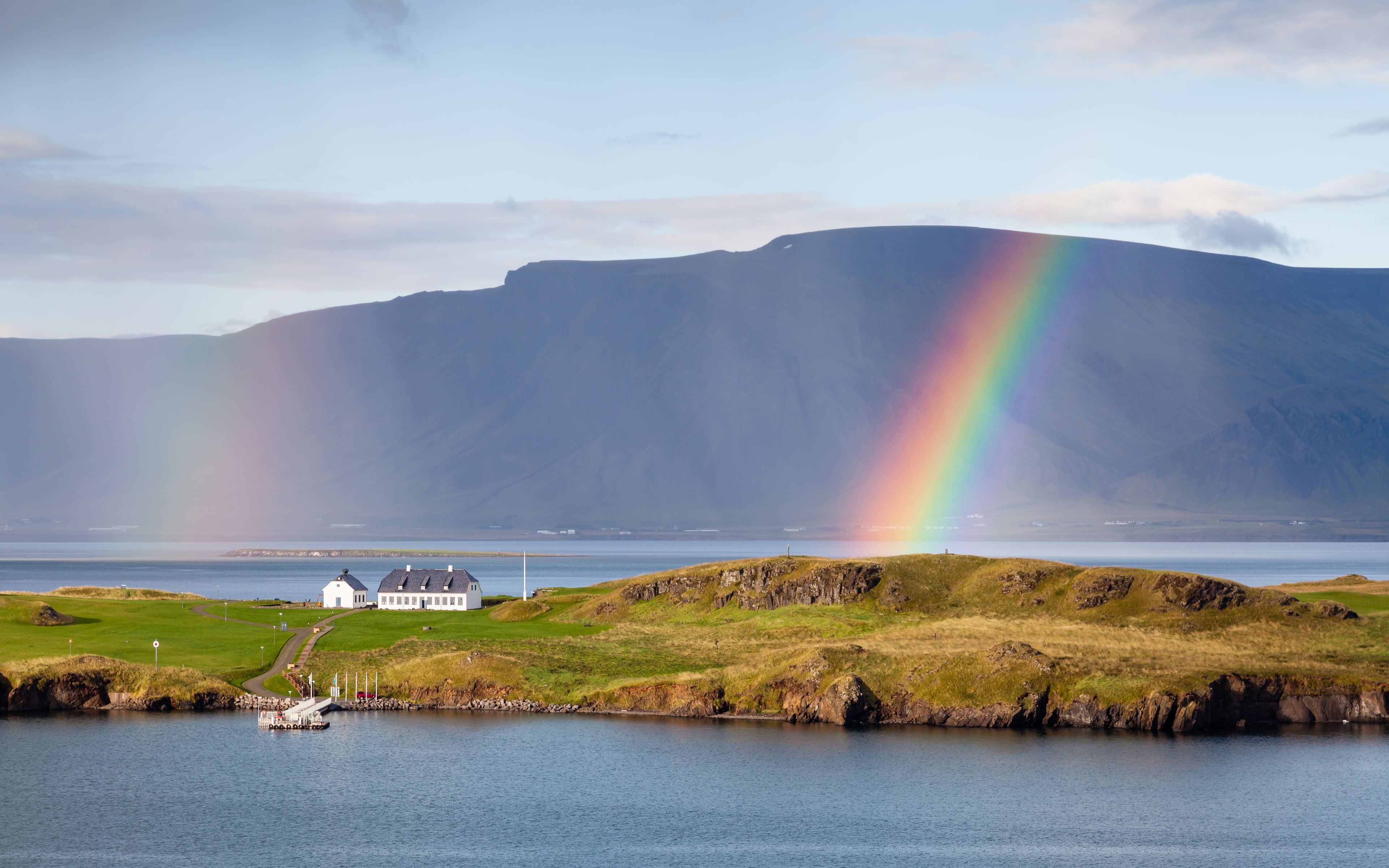 The view from Reykjavik harbour in Iceland as rain falls and a rainbow forms