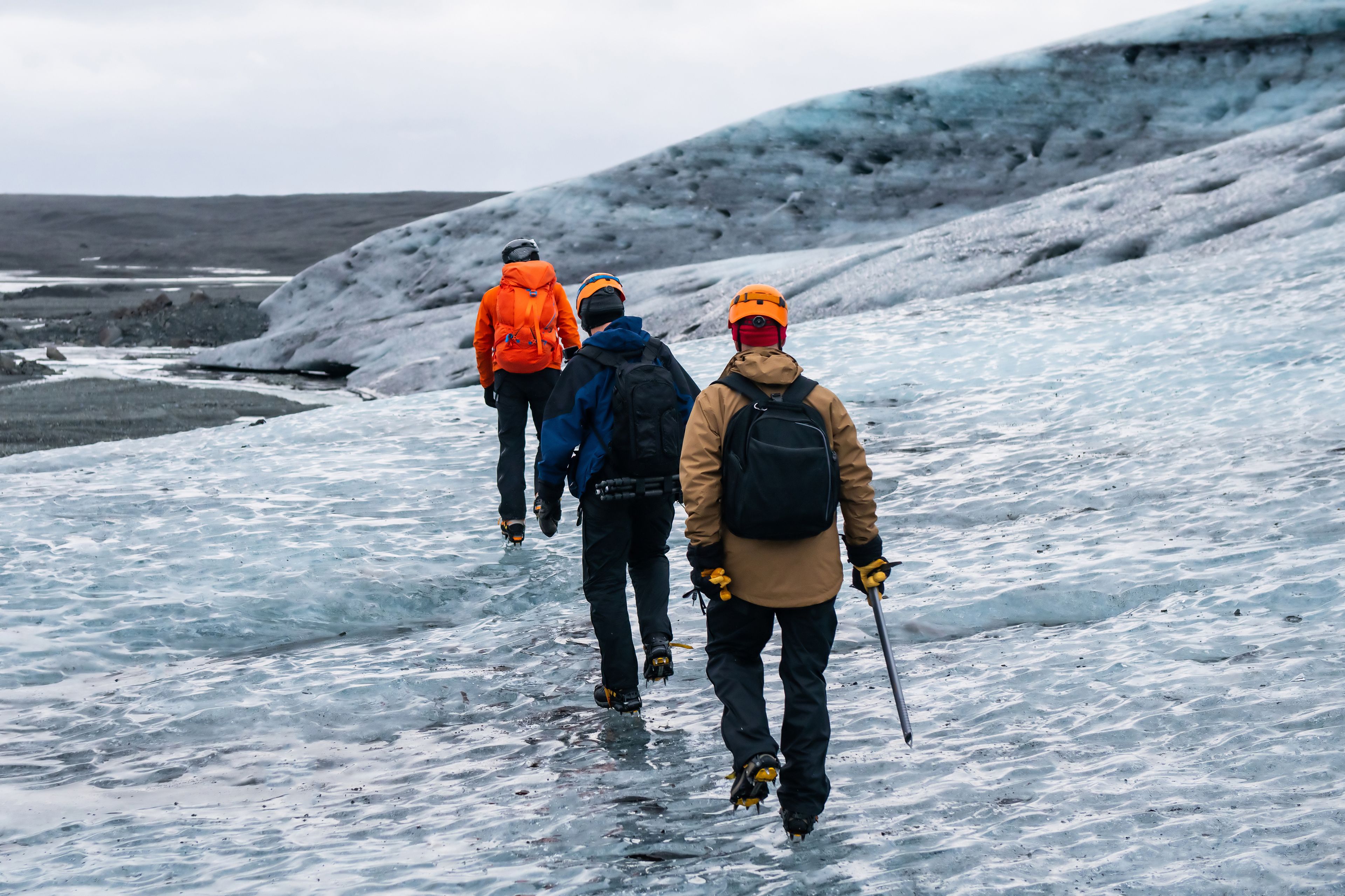 Tourists in helmets and crampons exploring a glacier surface in Iceland