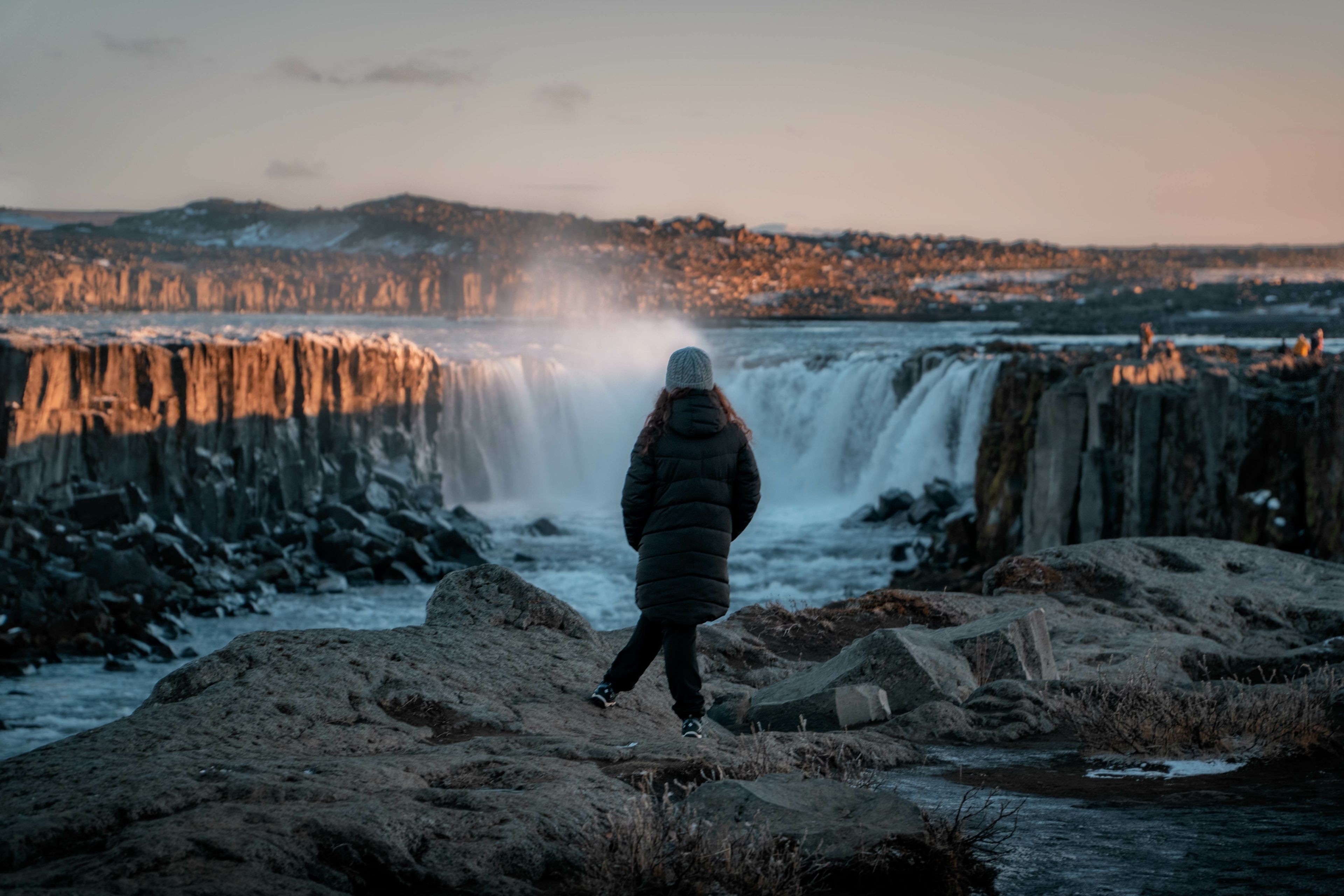 Girl wearing winter clothes admiring Selfoss waterfall