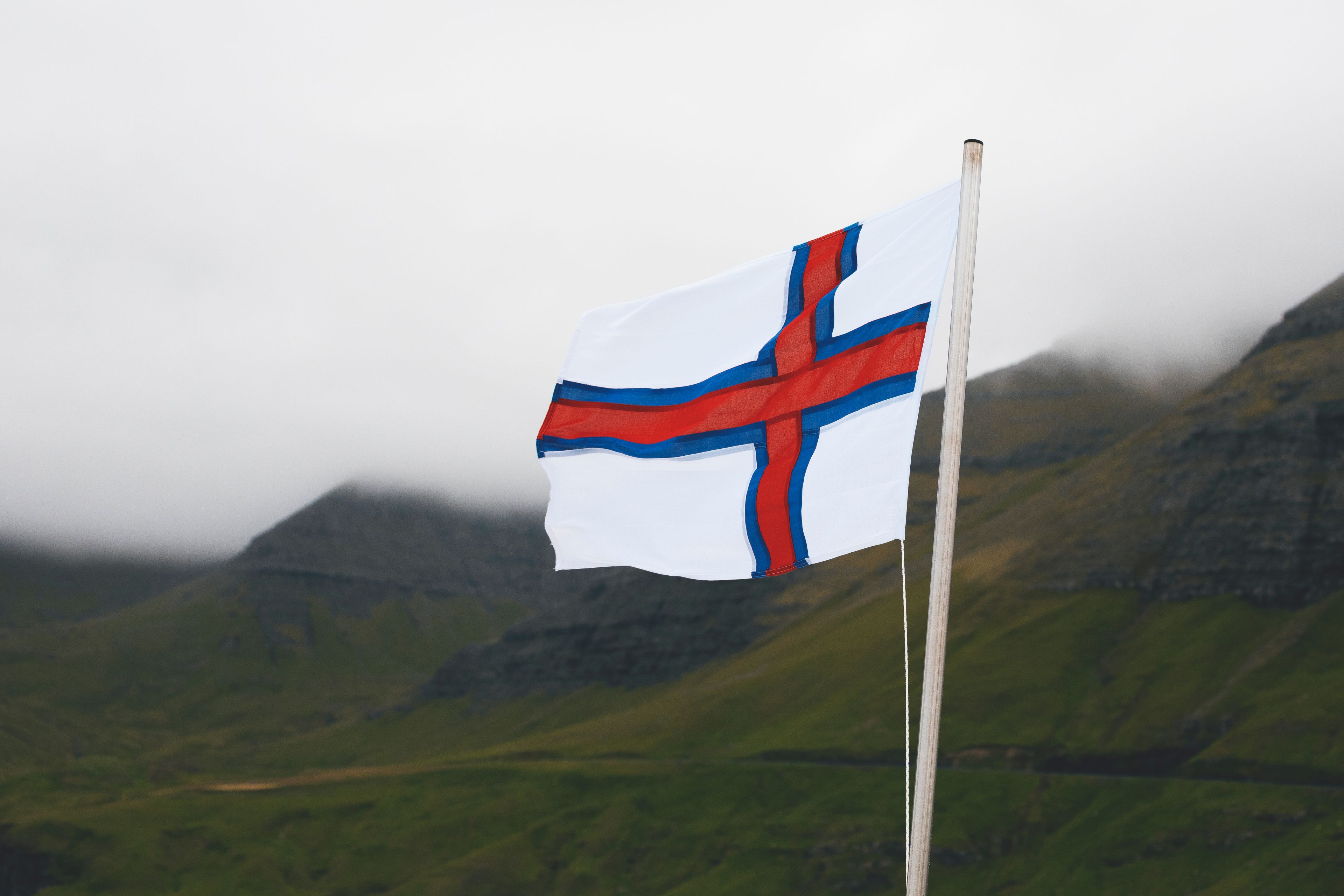 Faroe Islands flag on a rainy day by the cliffs