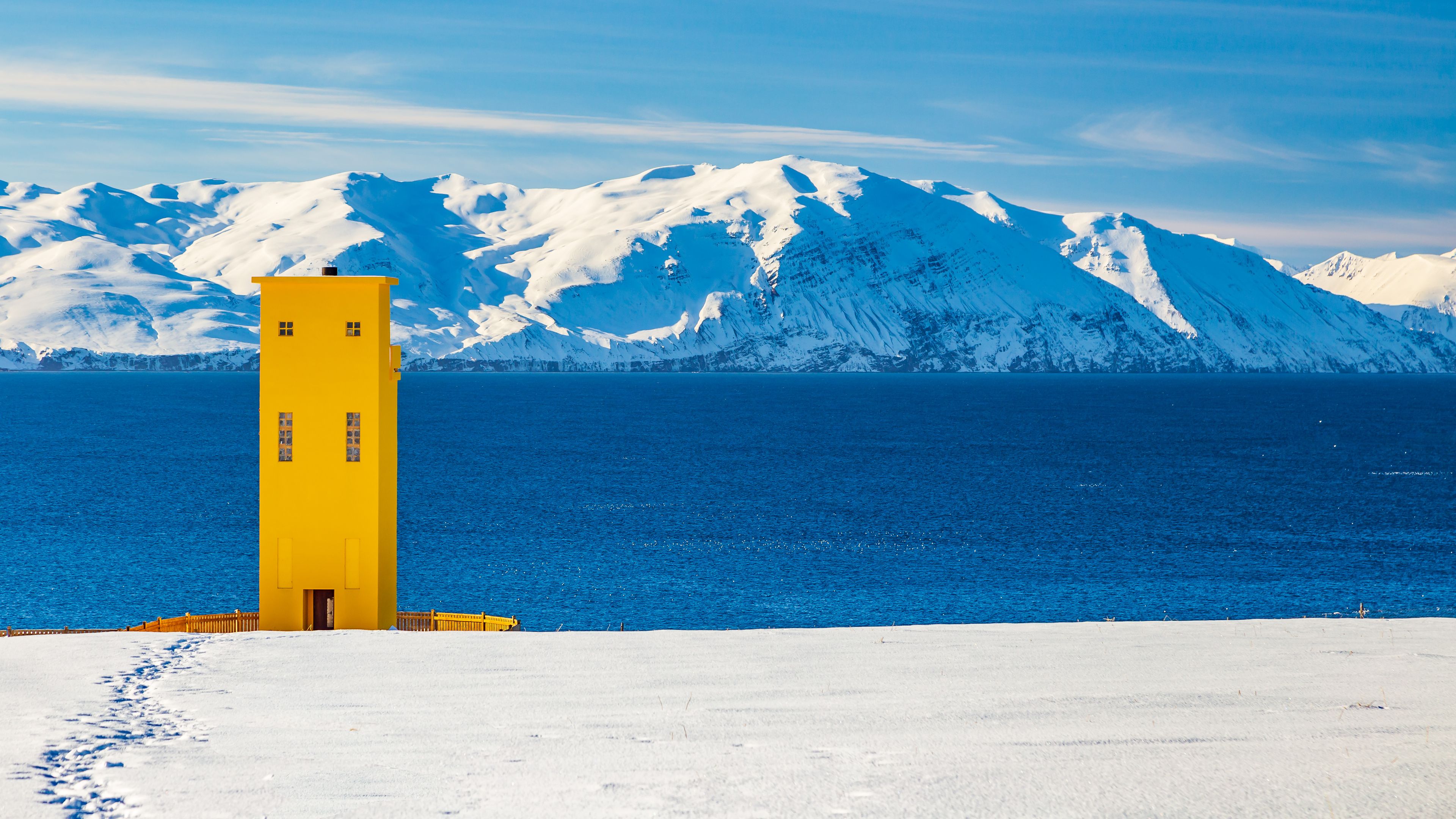 Husavik Lighthouse with snow-capped mountains in the background