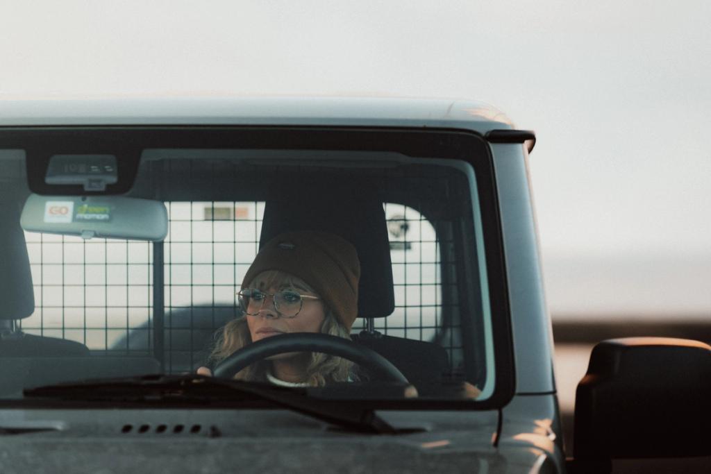Eine Frau in einem Suzuki-Jimny-Mietwagen