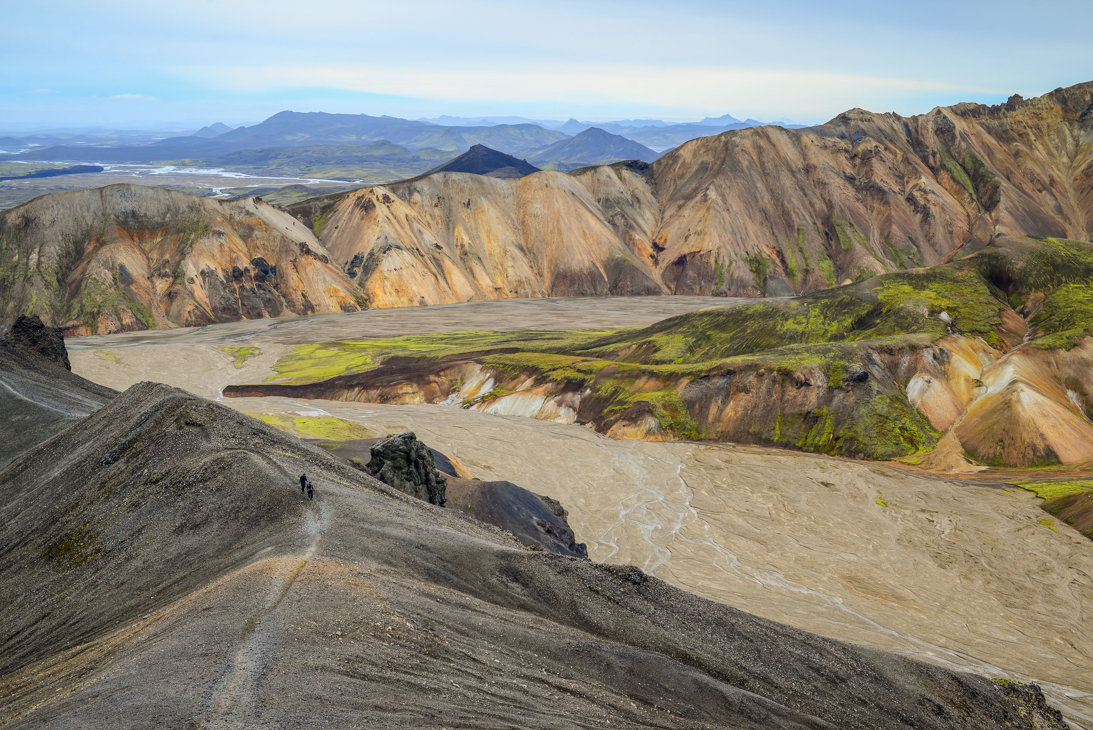 Two hikers on the ridge trail approaching the summit of Bláhnjúkur volcano