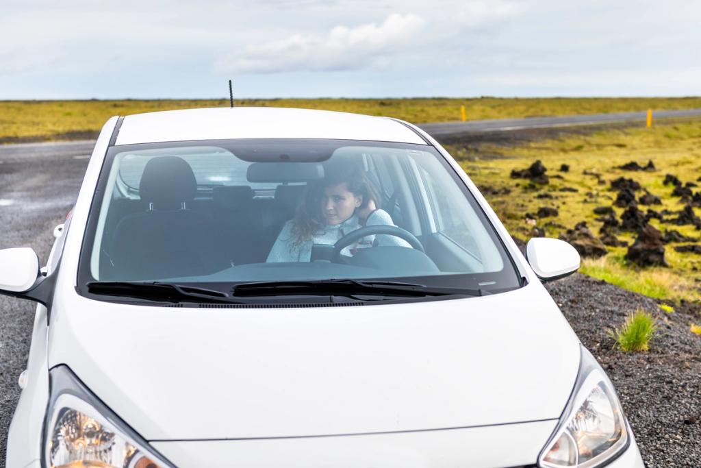 A woman in a Hyundai i10 rental car in Iceland, provided by Go Car Rental