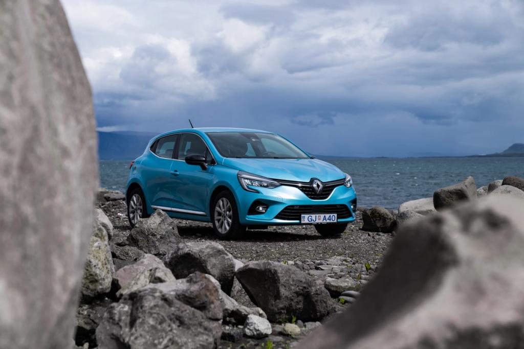 Blauer Renault Clio-Mietwagen auf Schotter geparkt