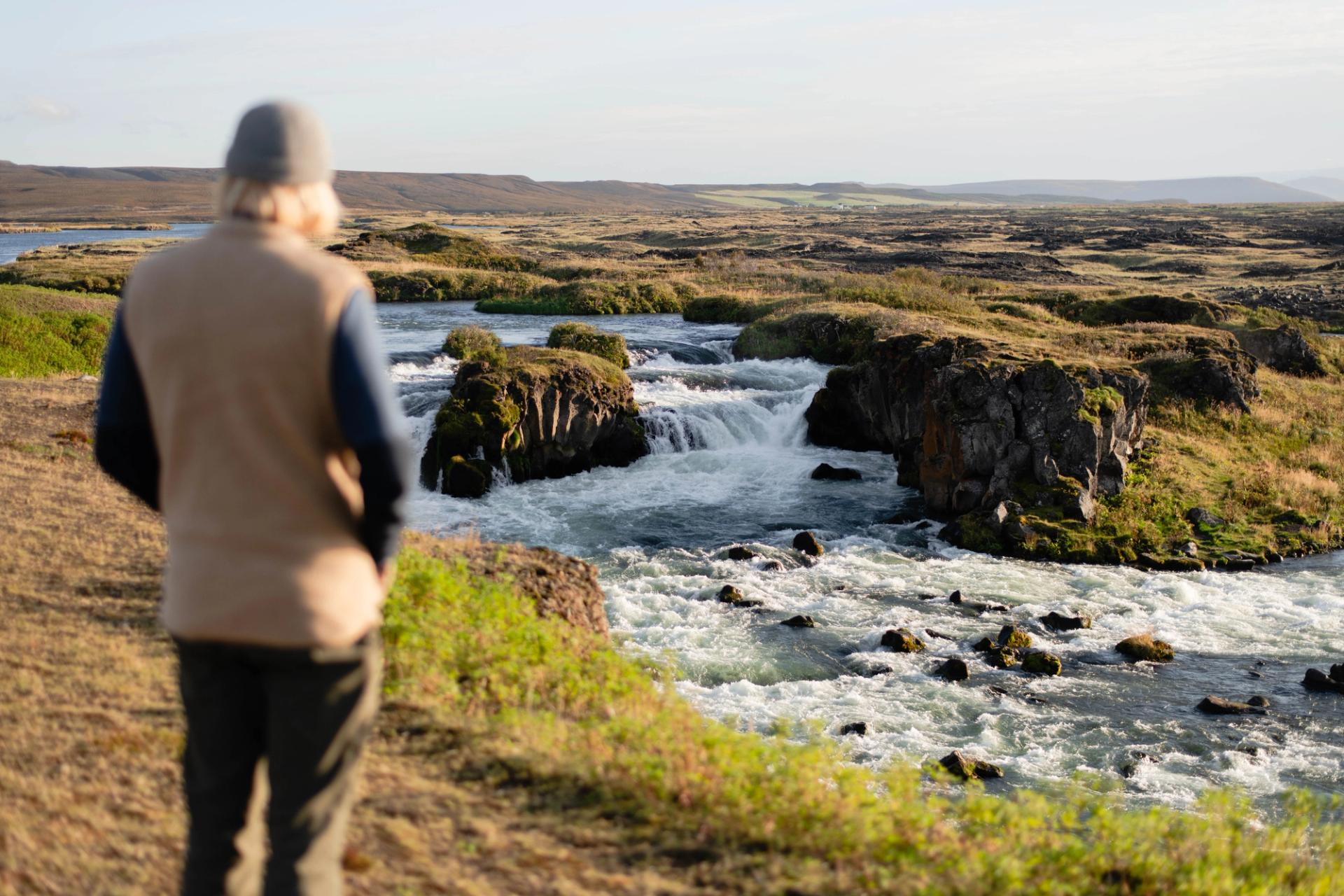 a man watching a waterfall in Iceland in fall 