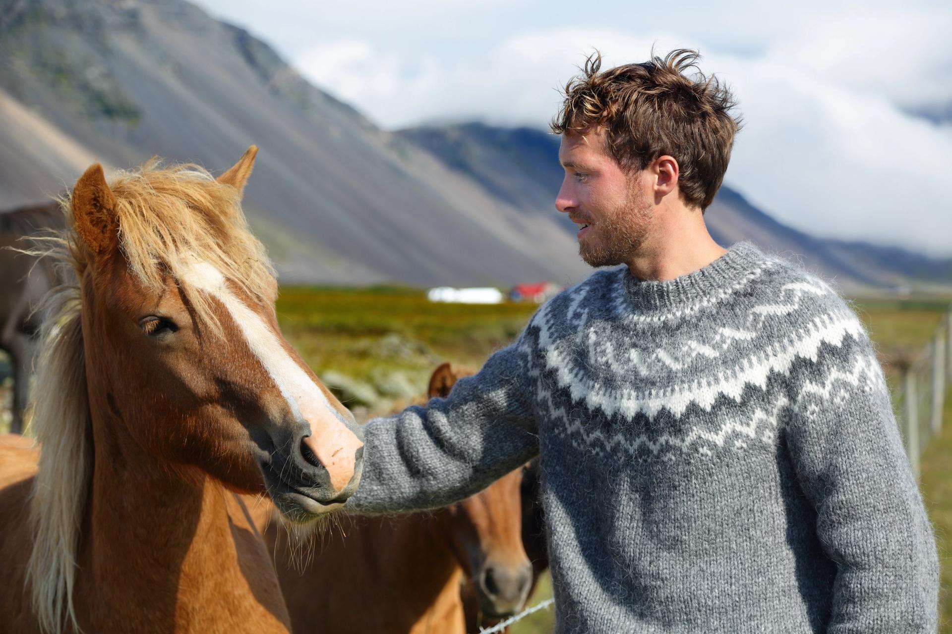 A man petting an Icelandic horse