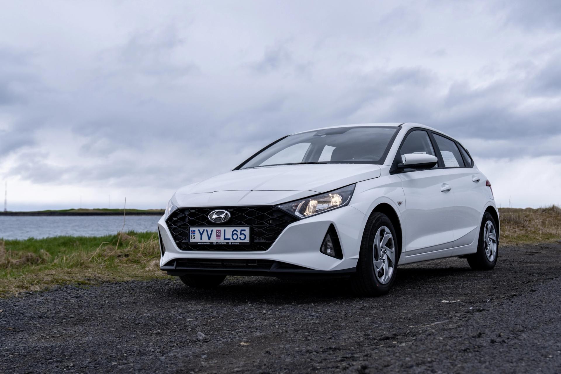 Hyundai i20 on a road in Iceland with a model standing 