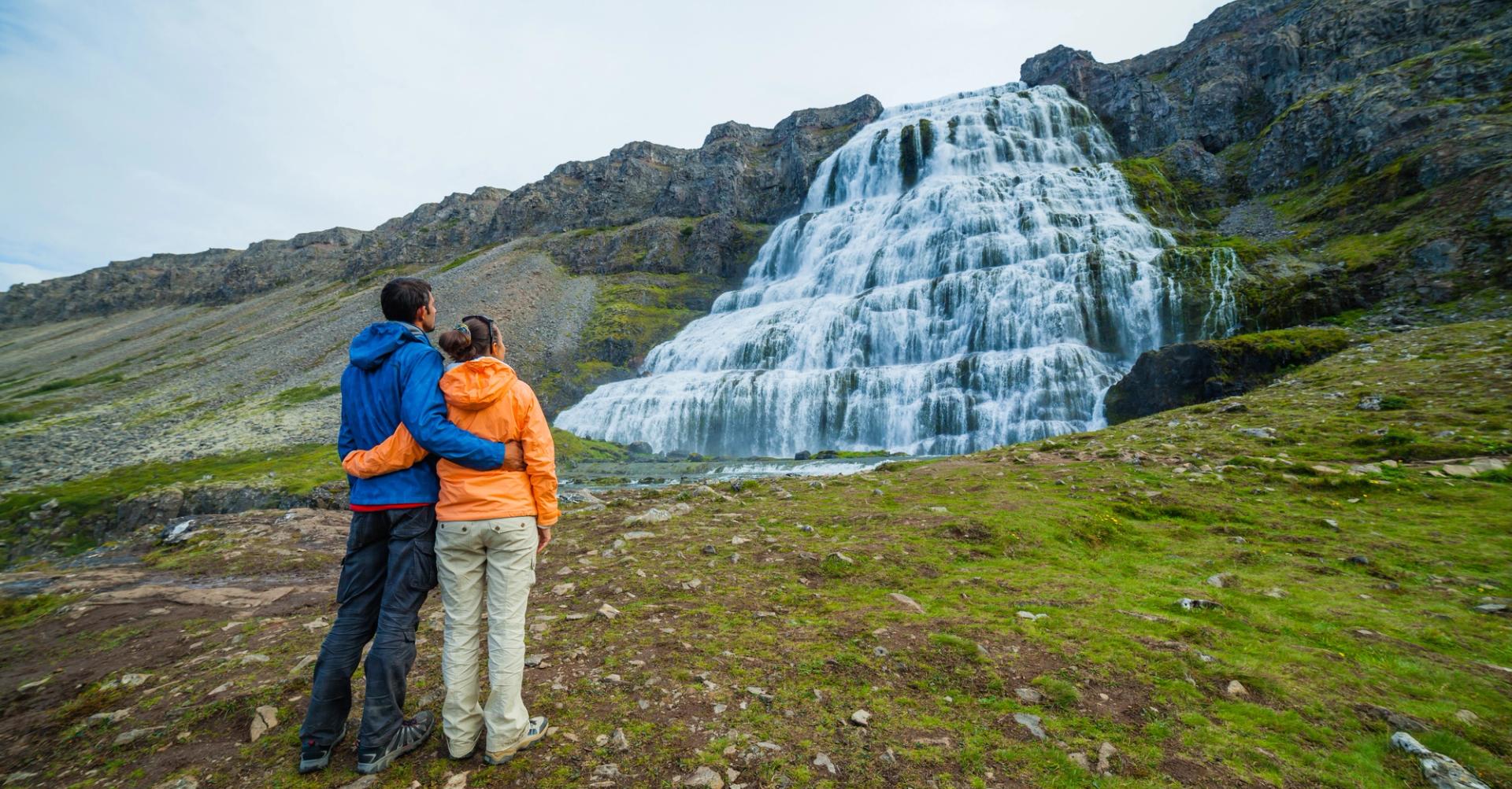 A couple watching a waterfall in iceland in September