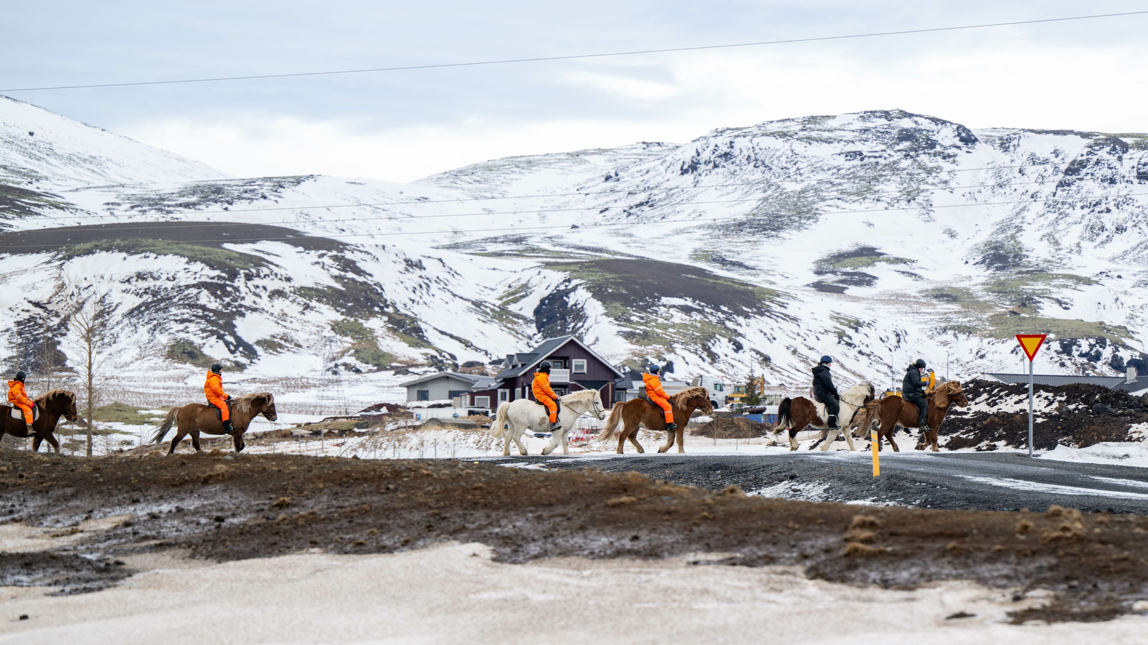 group of people riding horses in a snowy landscape