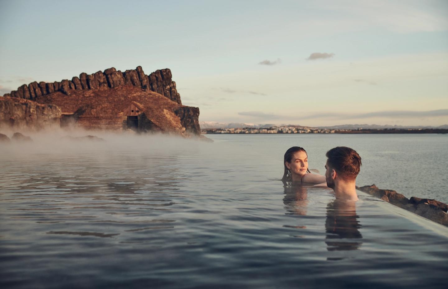 Woman and a man relaxing in Sky Lagoon hot spring Iceland