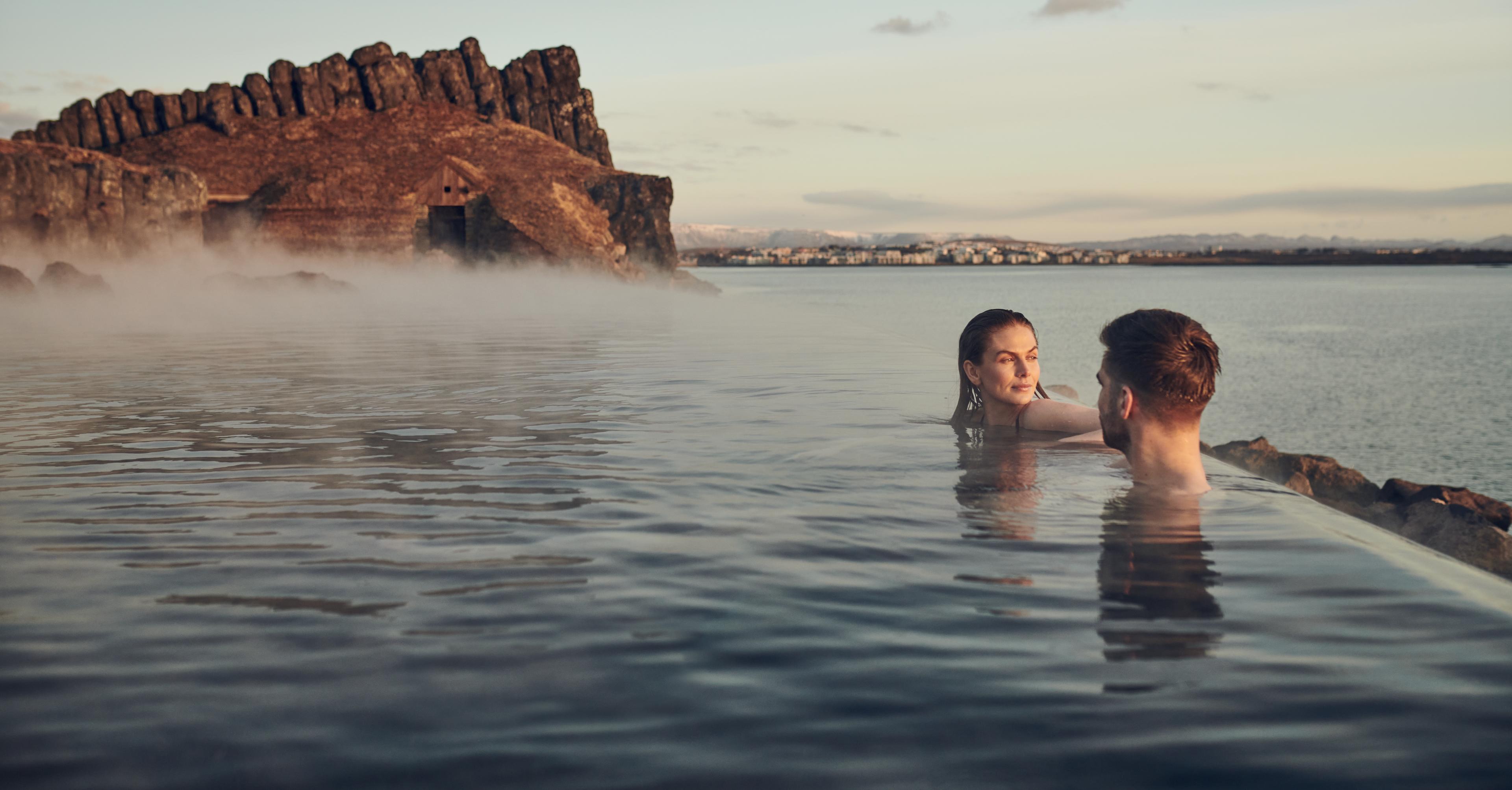 Woman and a man relaxing in Sky Lagoon hot spring Iceland
