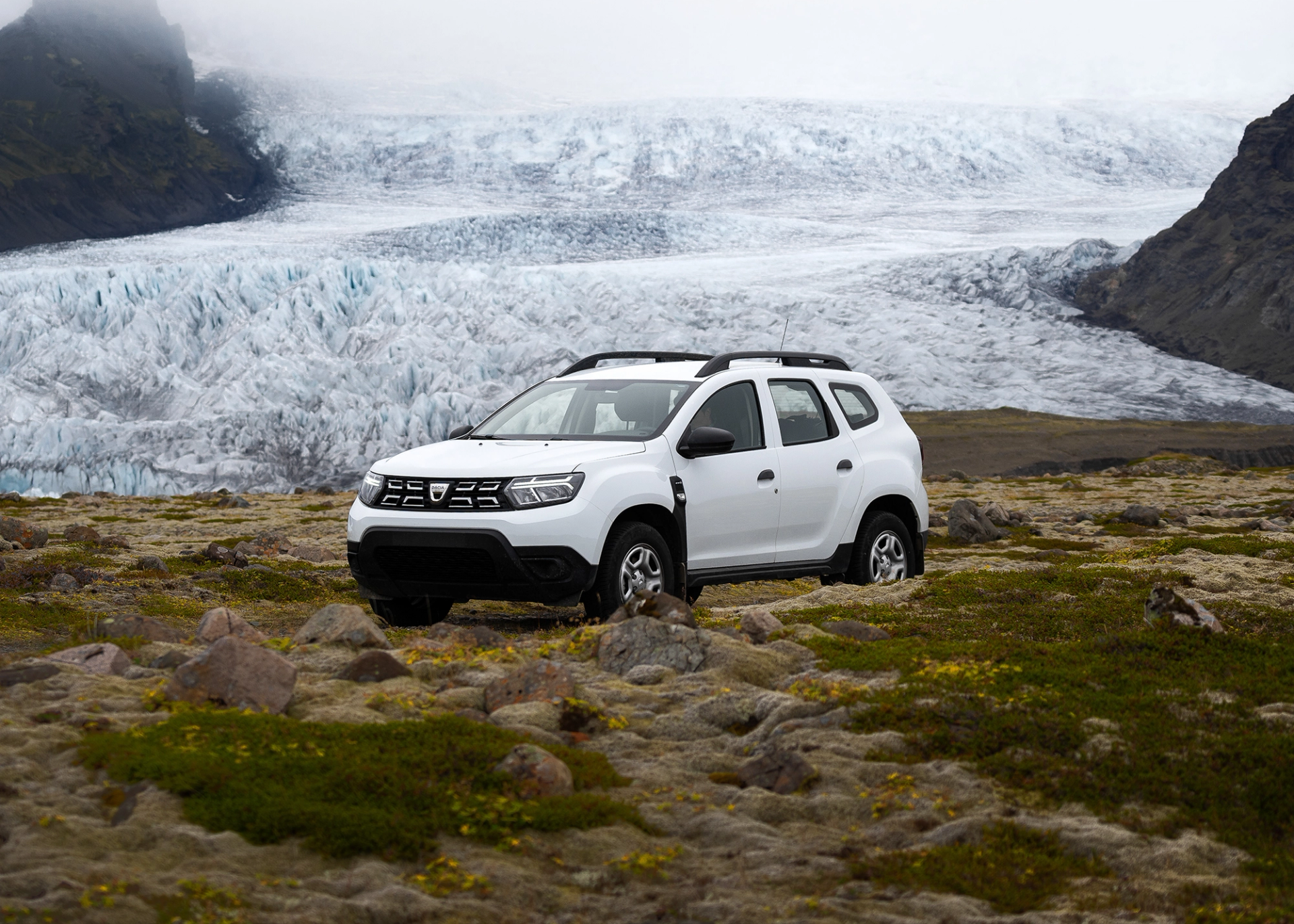 Dacia Duster rental car parked in Iceland near a ice glacier