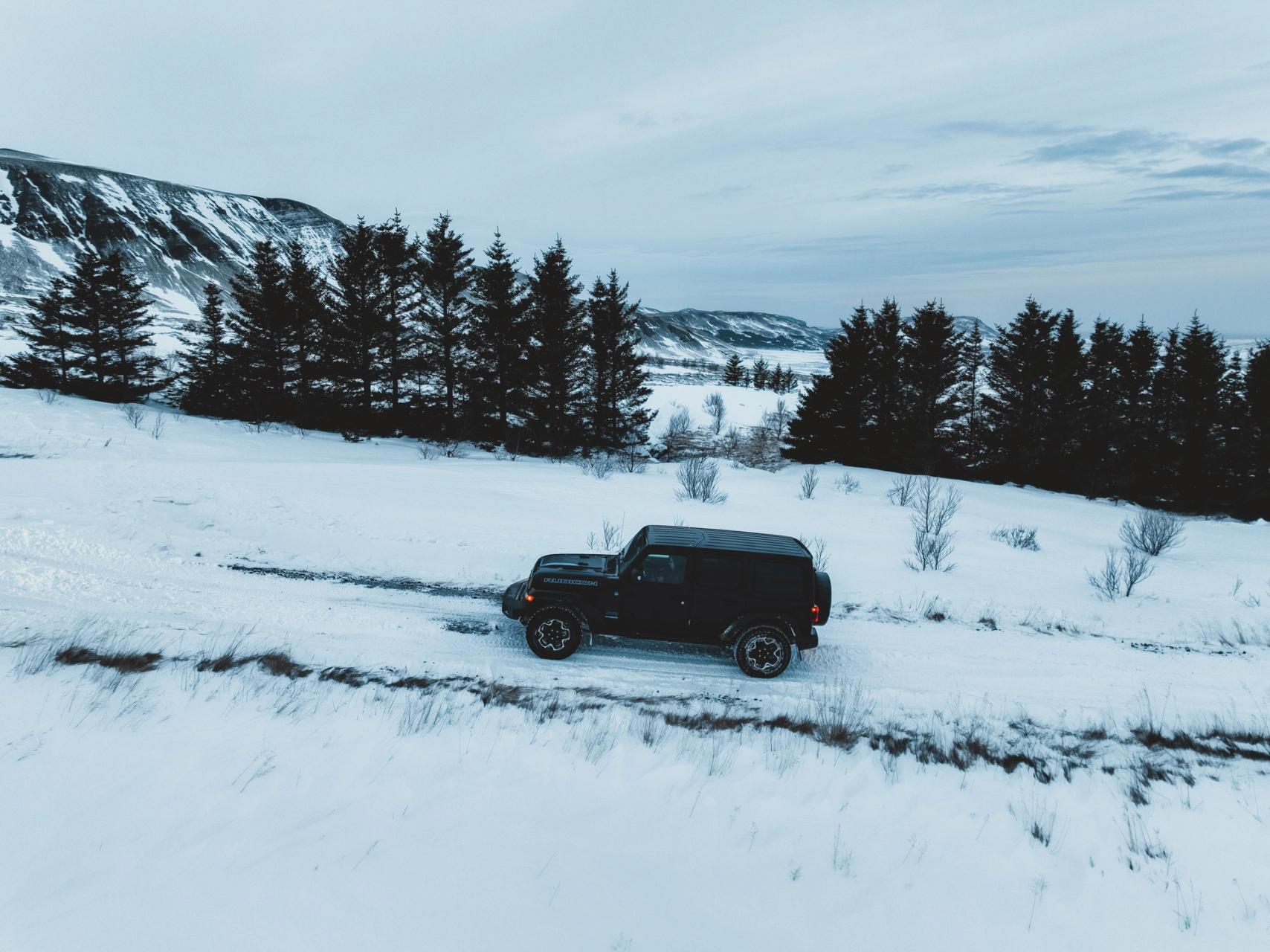 Black 4x4 in the cold landscapes of Iceland where the snow is predominant