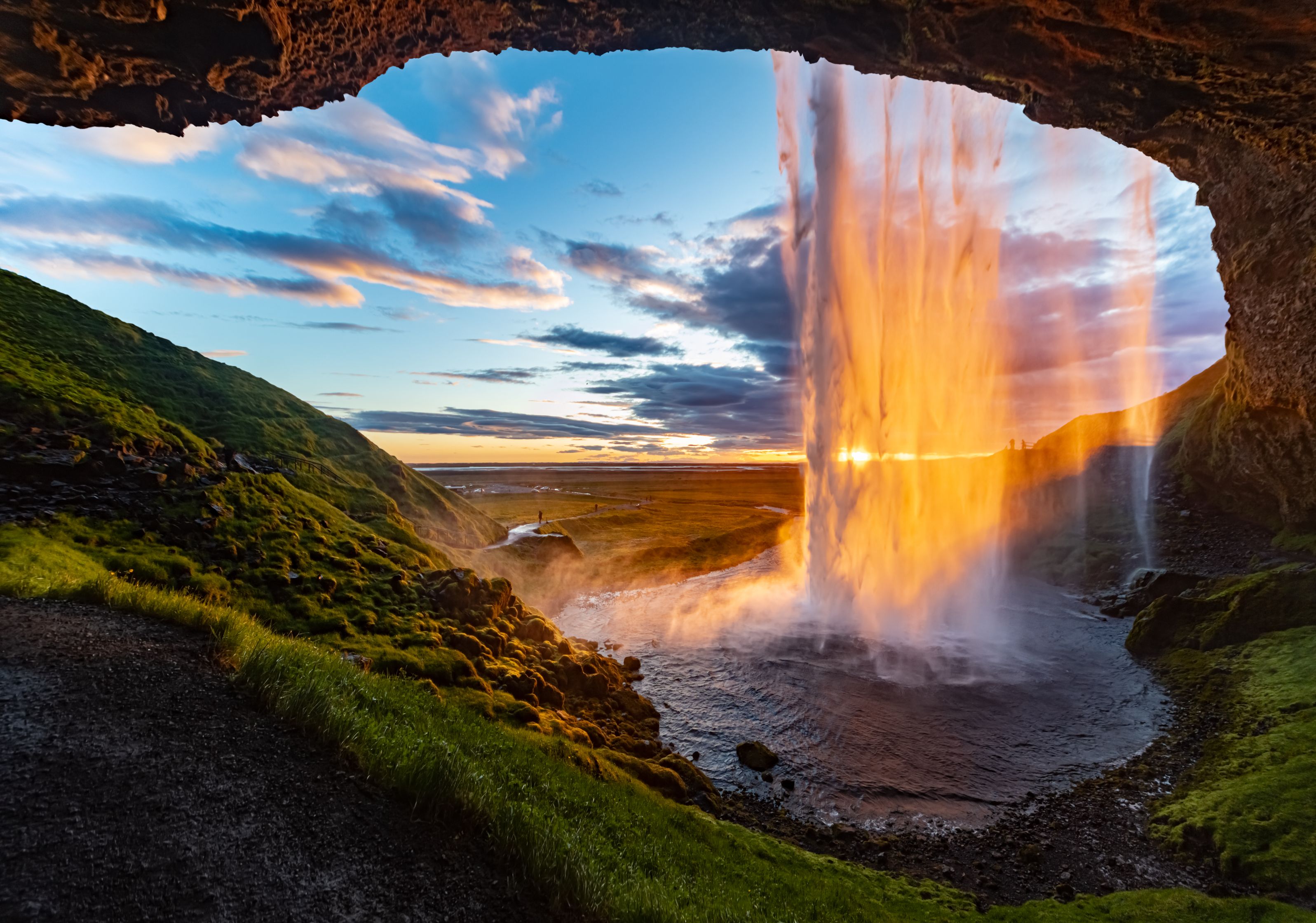 sunset behind a beautiful waterfall in iceland