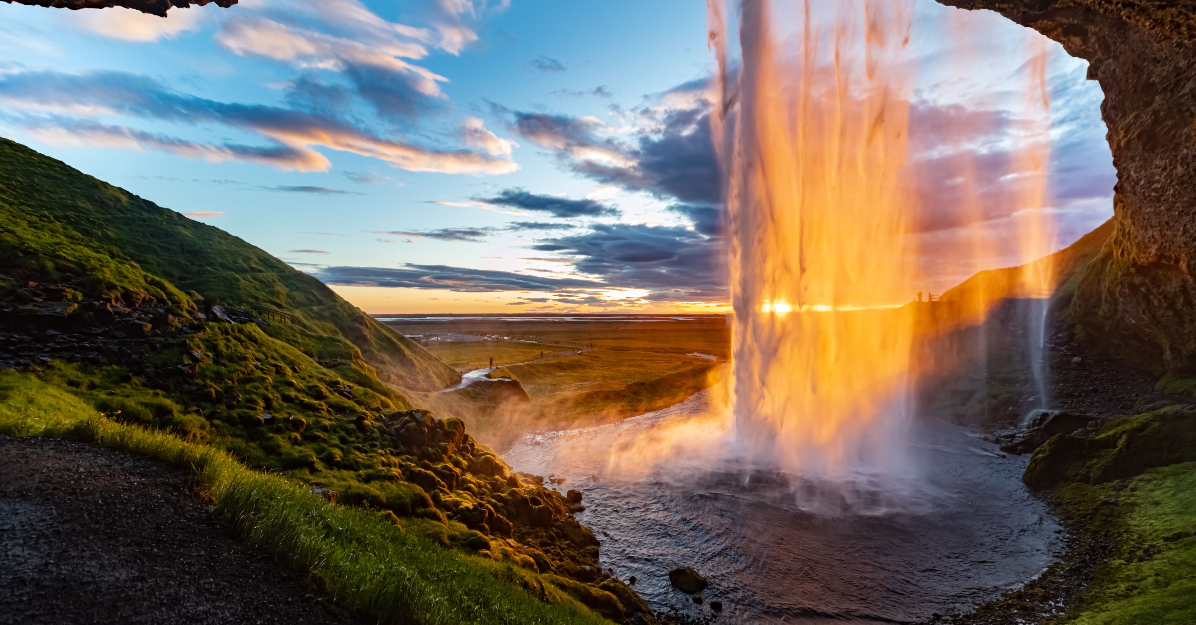 sunset behind a beautiful waterfall in iceland