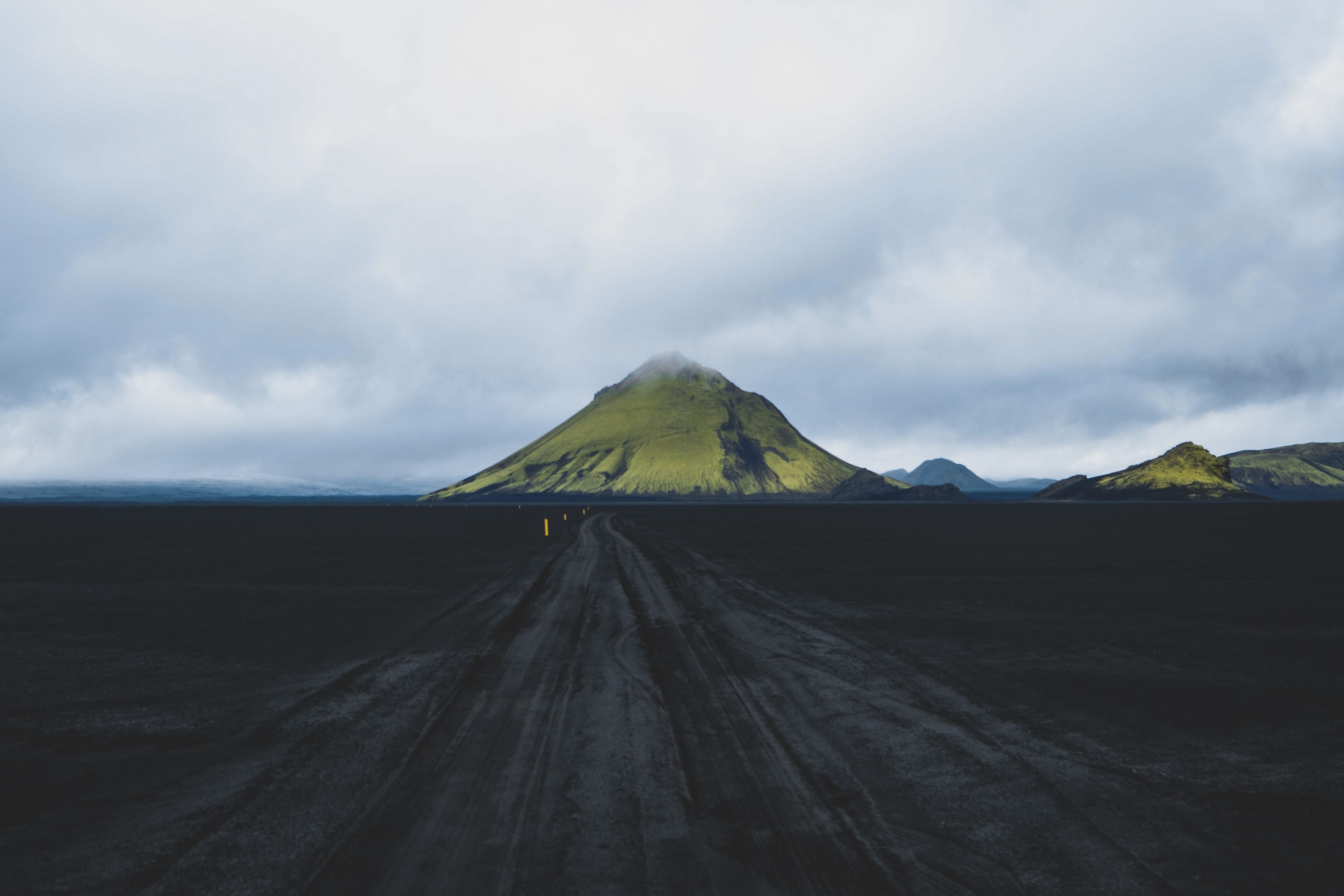 The black sand road to the green Mount Mælifell in Iceland