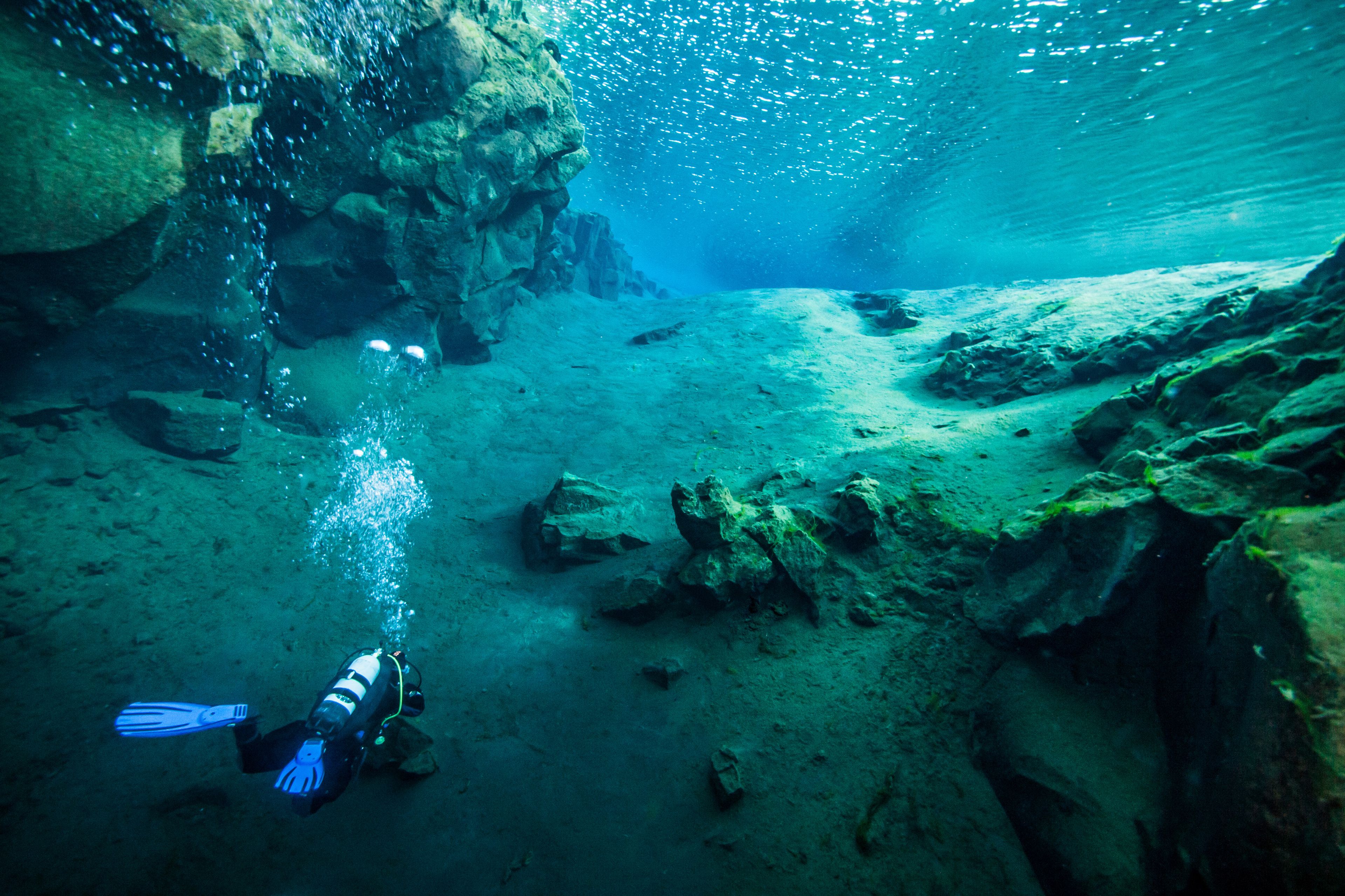 A man diving in silfra fissure in iceland