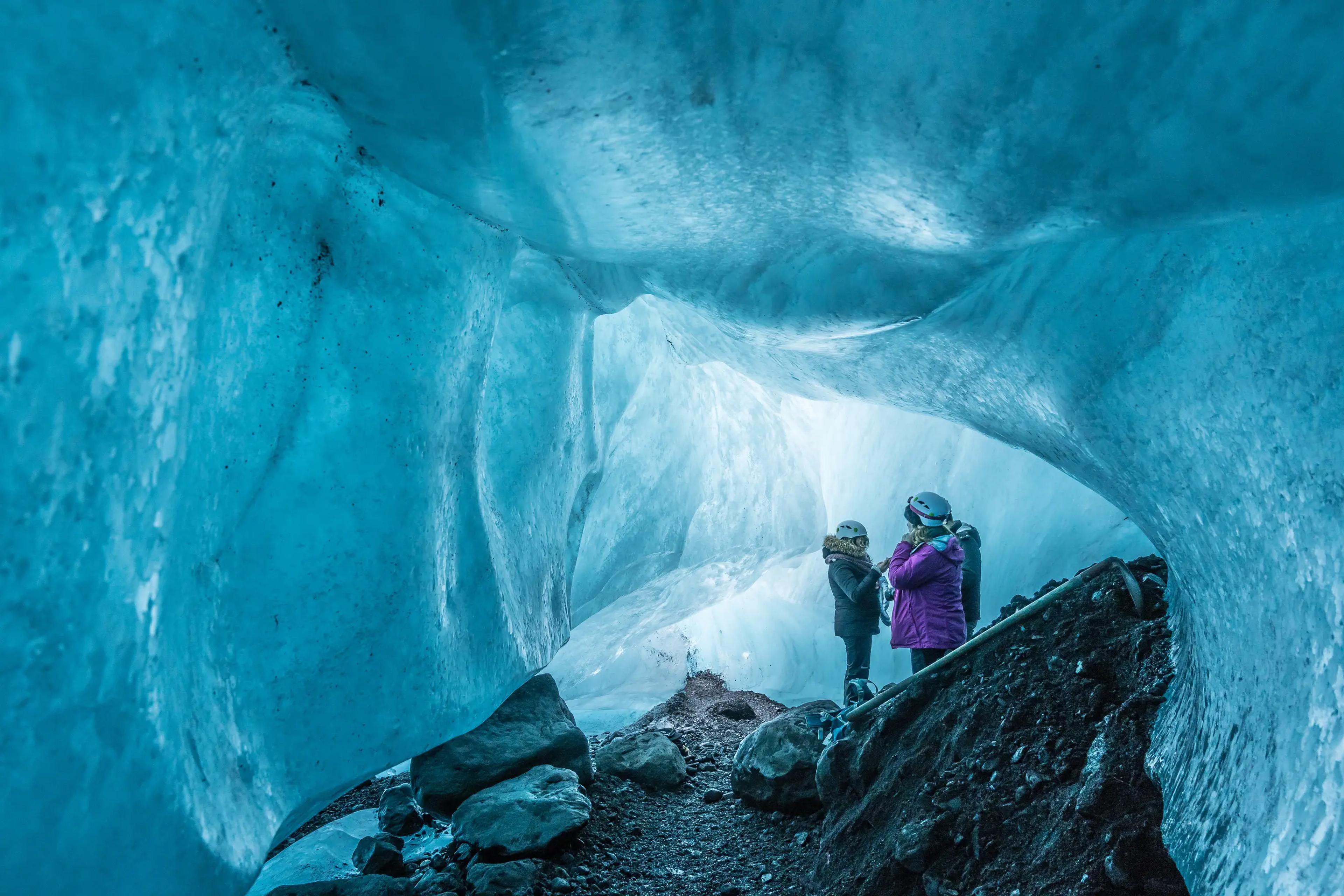 Personas explorando cuevas de hielo en Islandia