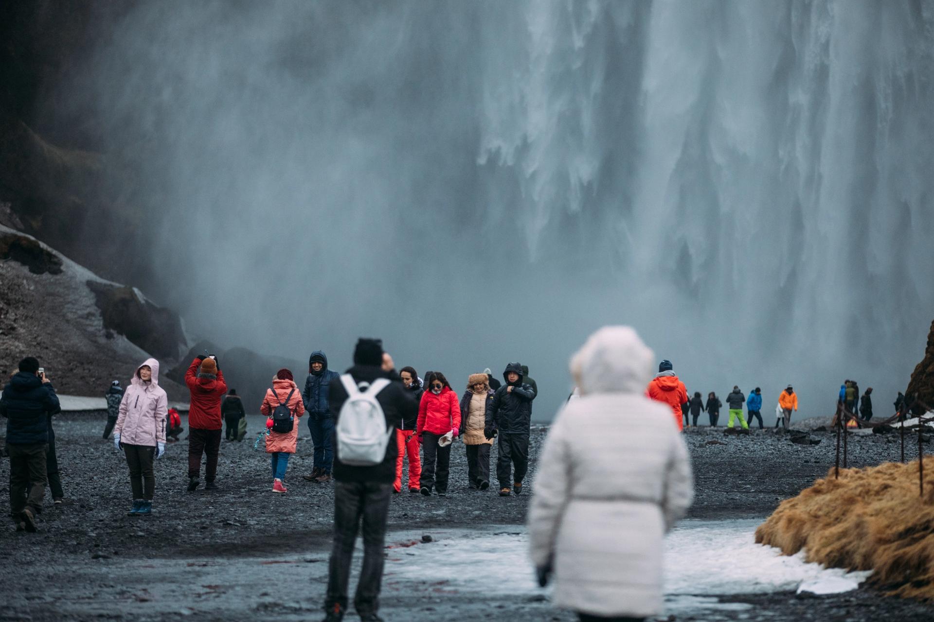 around 50 tourists in Iceland watching a waterfall