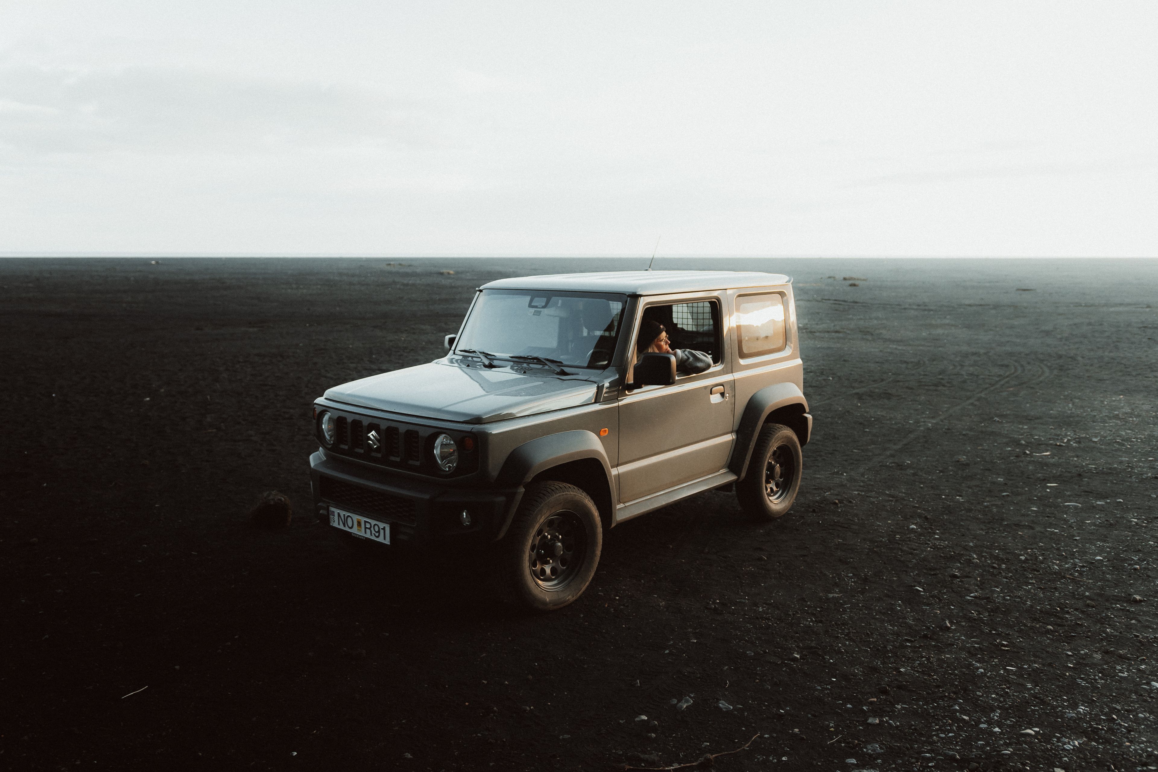 A Suzuki Jimny rental car parked against the stunning backdrop of Iceland's natural beauty.