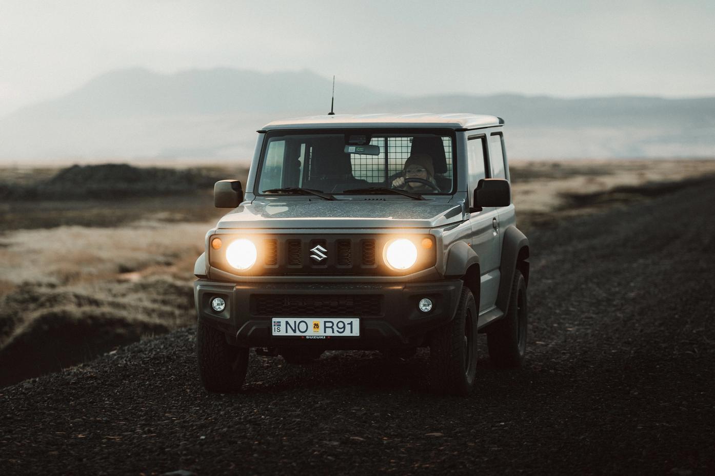 A 4x4 rental car traveling on a scenic road, part of the Golden Circle route in Iceland.