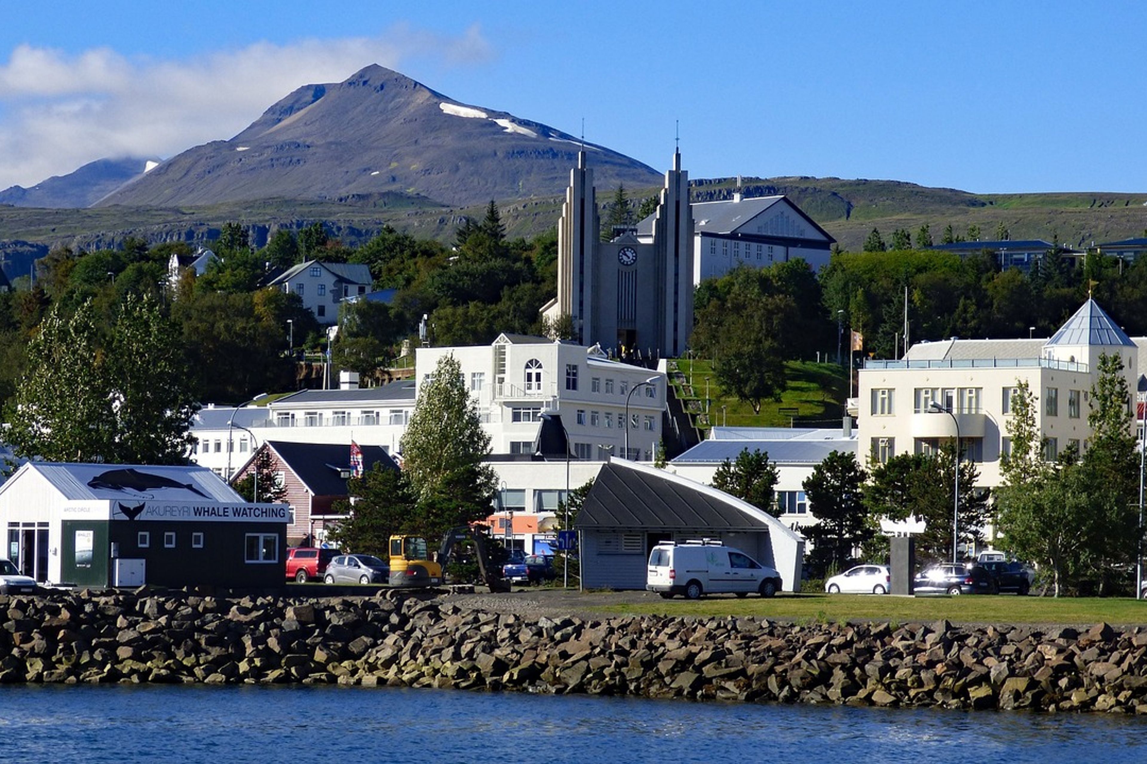A panoramic view of Akureyri, Iceland's second-largest city, nestled by the fjord with mountains in the background.