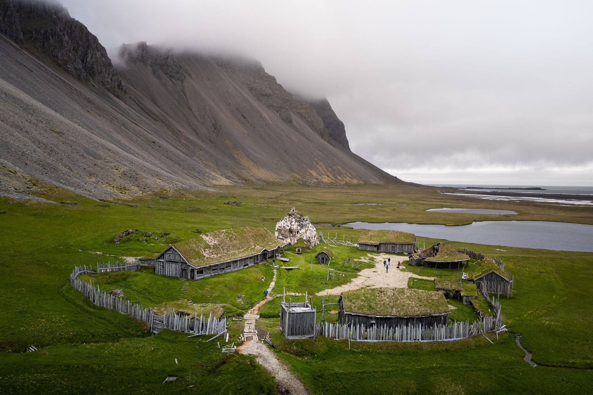 Vikings village and its green landscapes in Iceland surrounded by rocky hills on cloudy weather