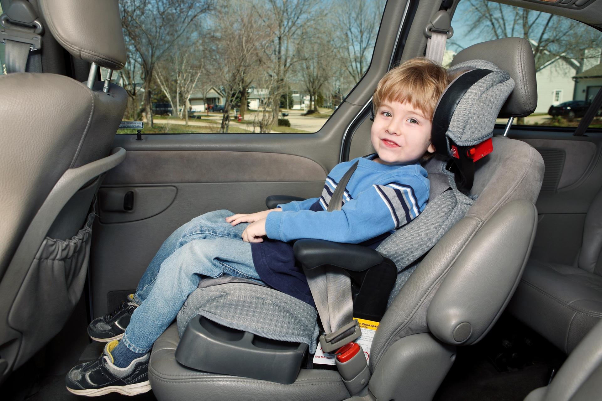 A kid sitting in a booster seat 