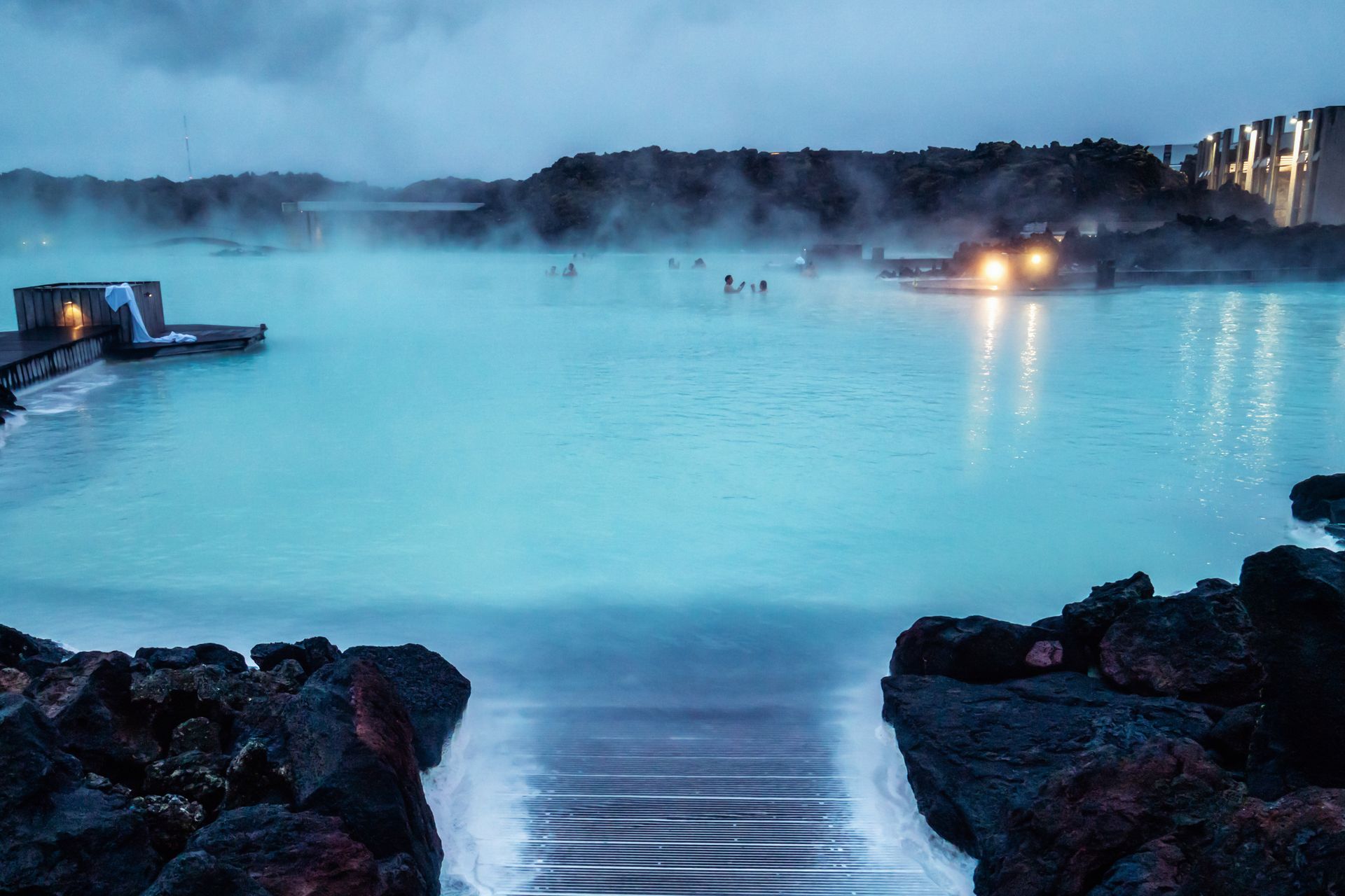 A blue water hot spring in Iceland with few people relaxing