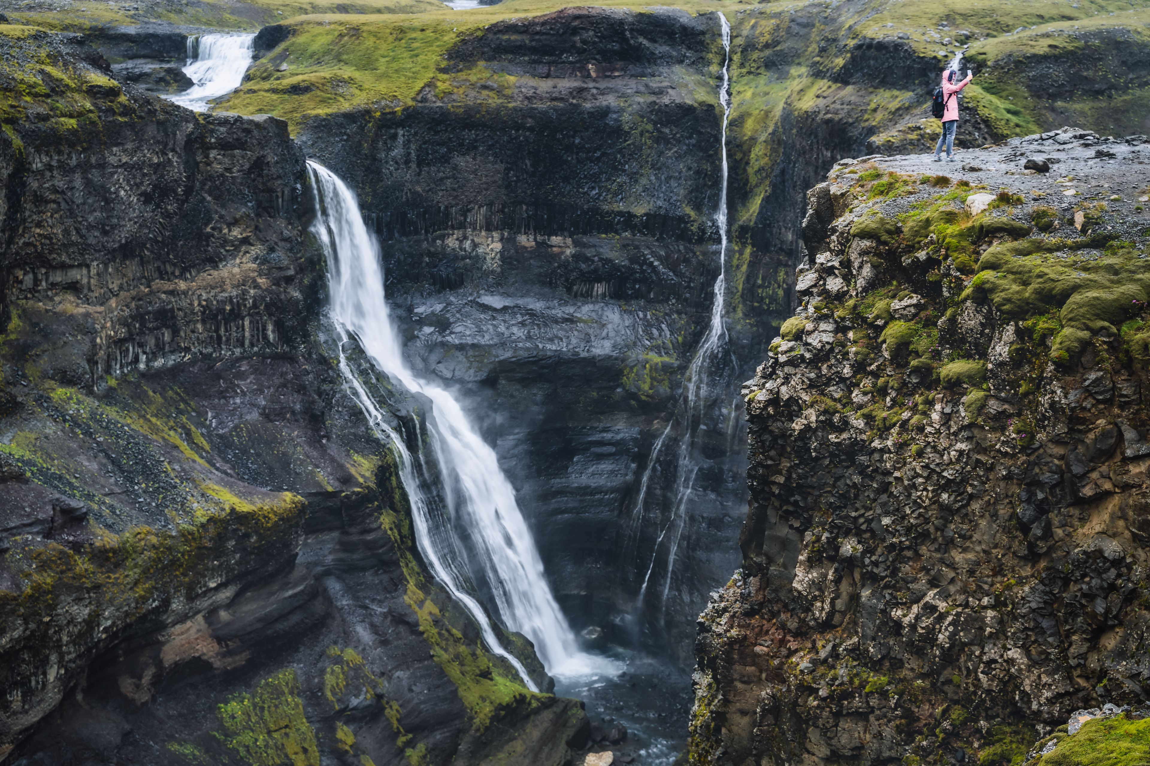 Tourist taking a selfie in front of Granni Waterfall, Iceland