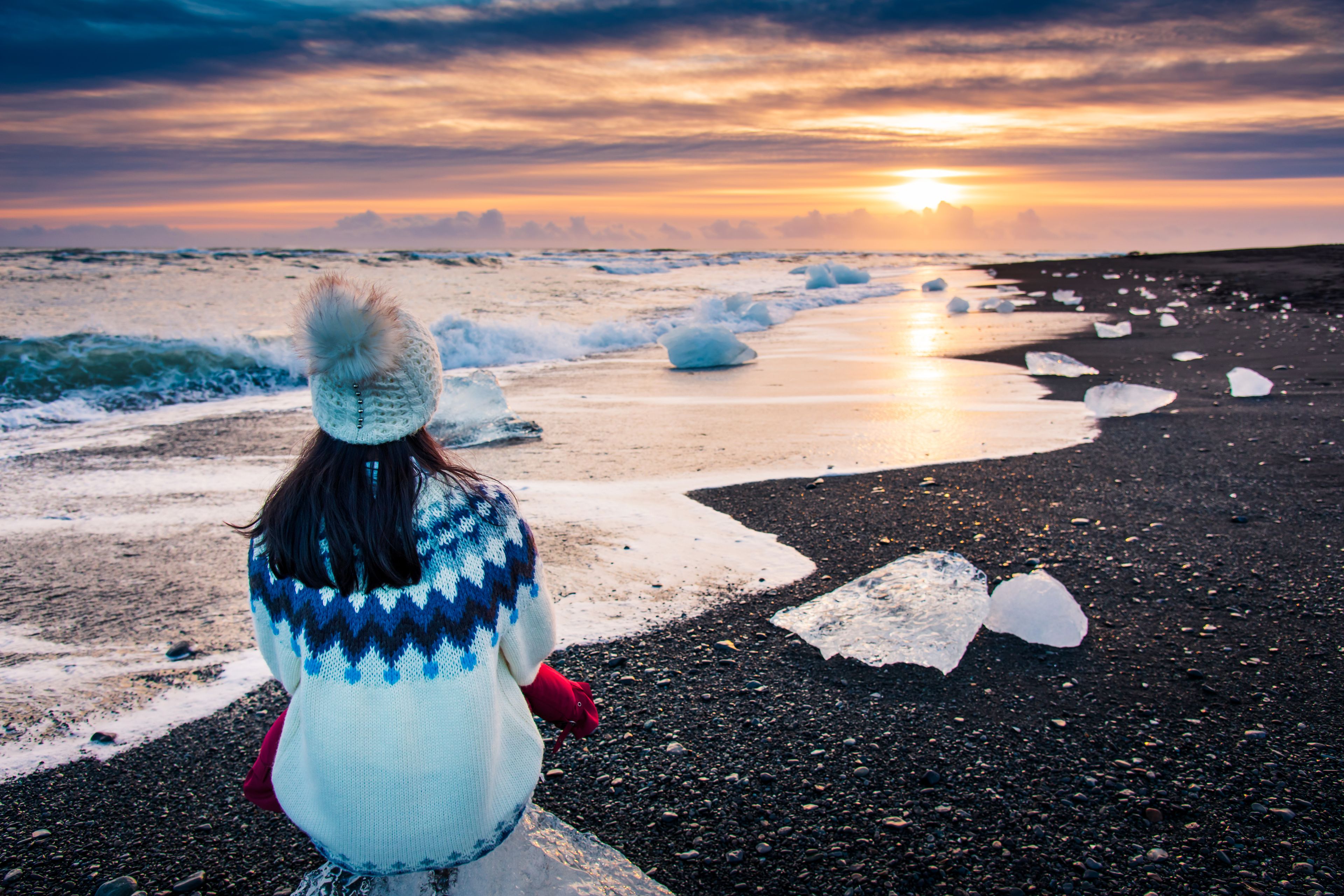 woman admiring the sunset on the diamond beach in winter