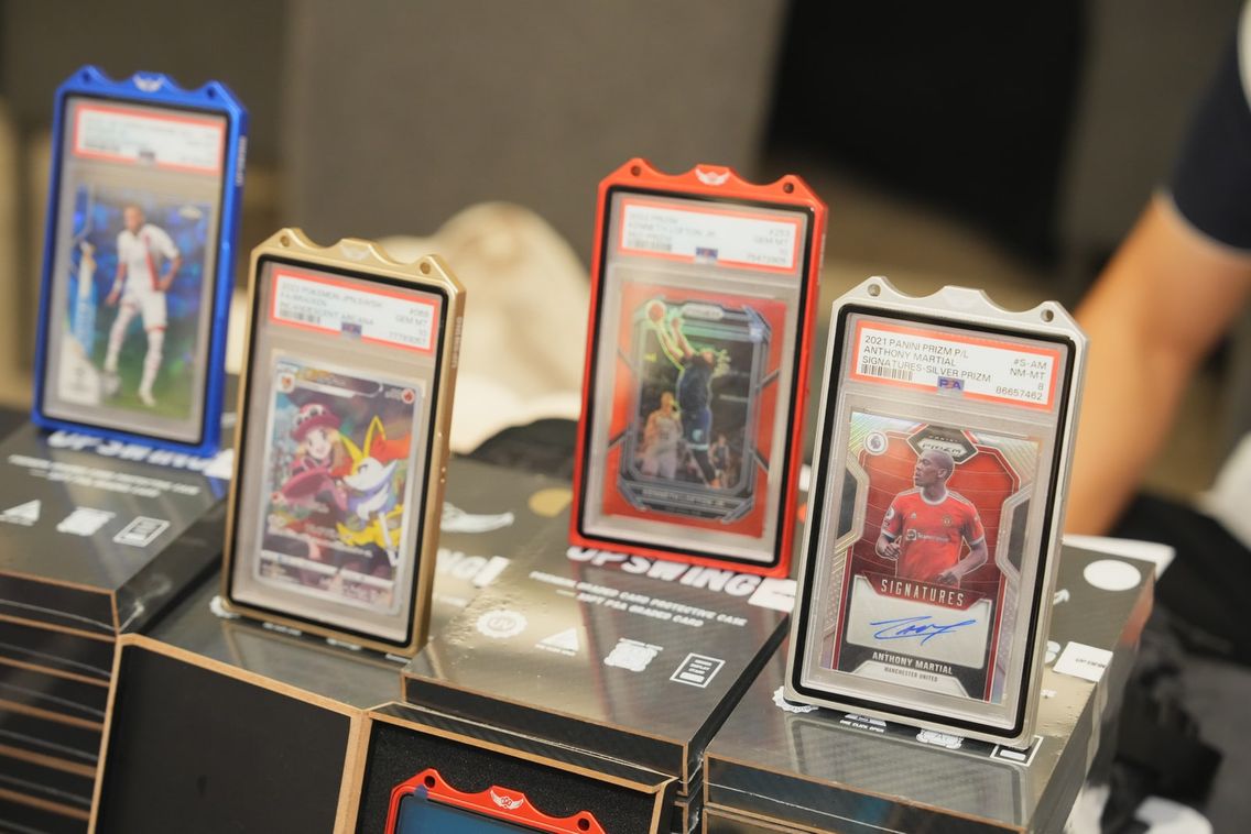 PSA-graded trading cards displayed in coloured slab holders at a Grade10 showcase.