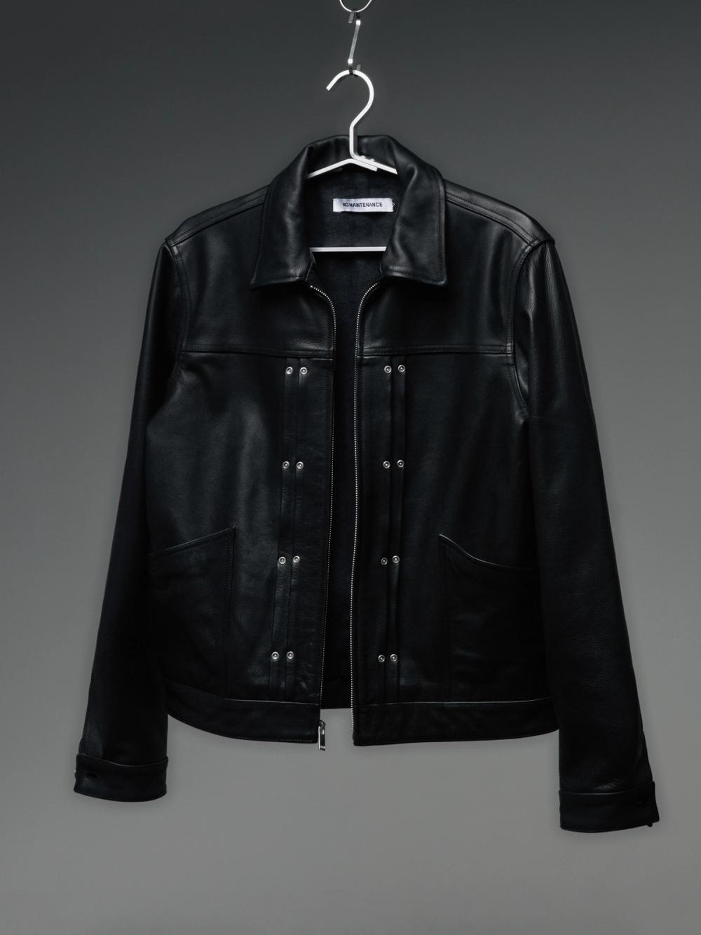 Black leather jacket with a collar, zipper, and silver hardware, hanging against a gray background.