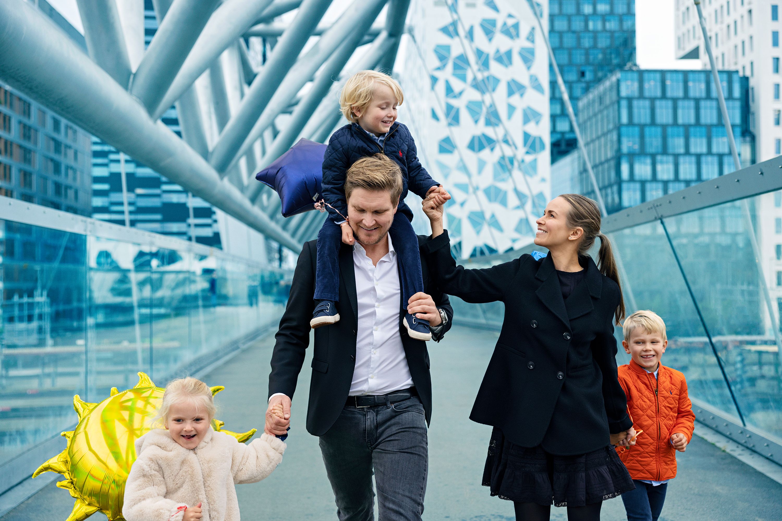 En familie med tre barn går over en bro