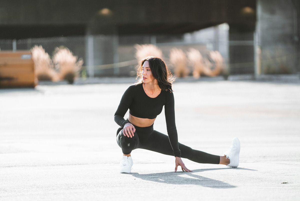 Gym-goer in black seamless leggings tying her trainers before a workout