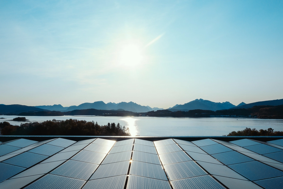 Solar panels with water and mountains in the horison