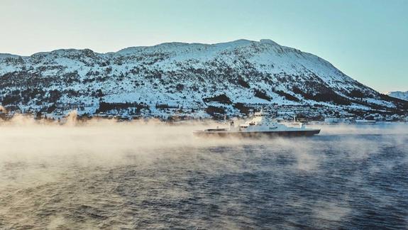 Winter view of an electric ferry cruising a foggy bay