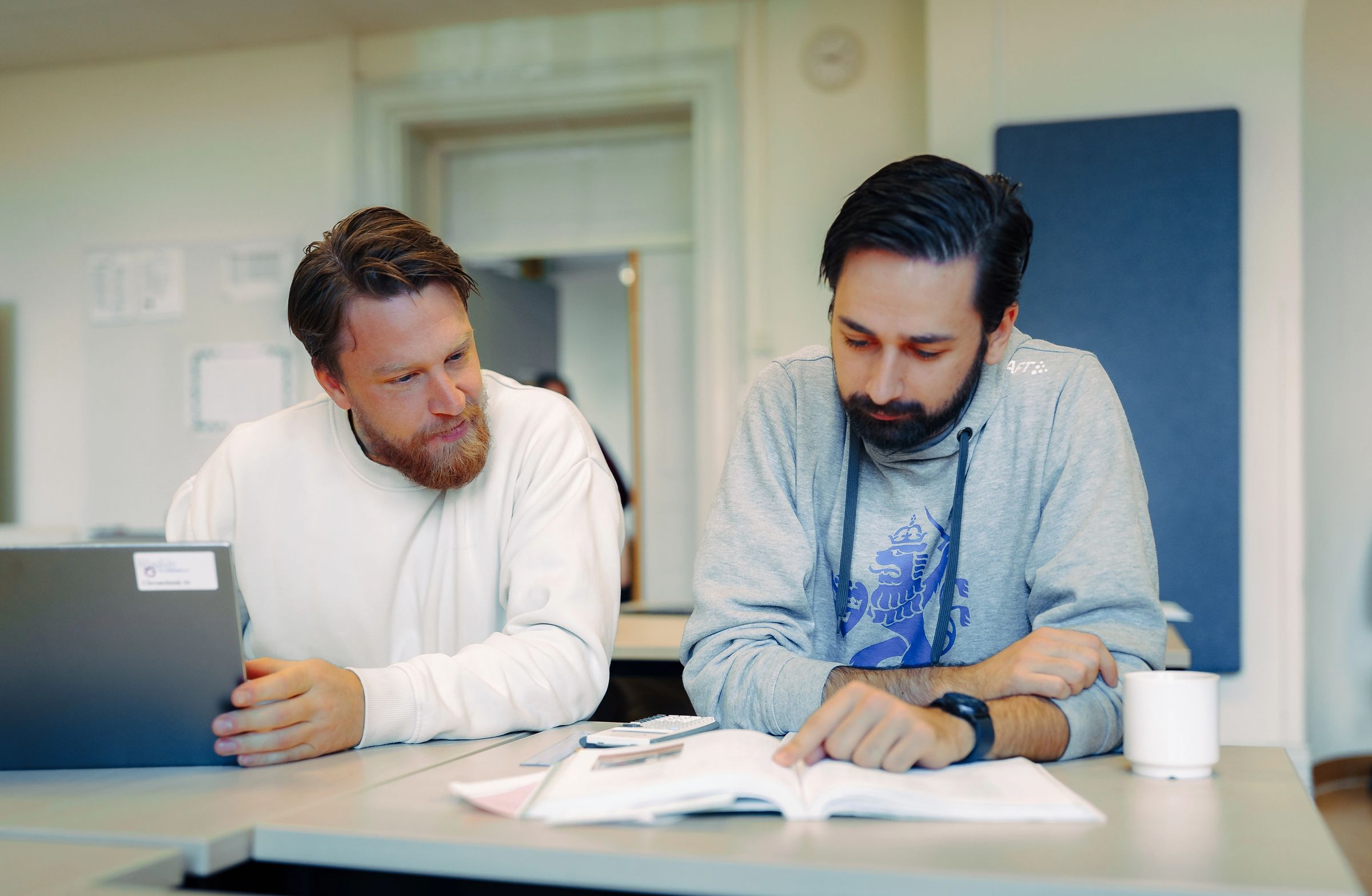 En grupp deltagare gör paus-gympa i ett klassrum. 
