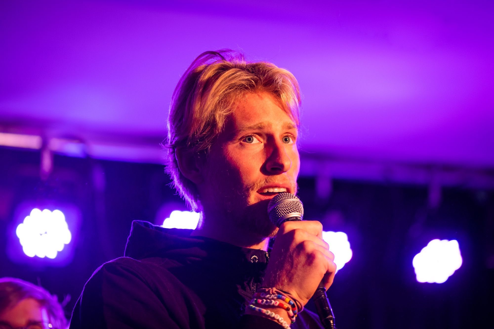 En man sjunger på en scen med fin ljussättning