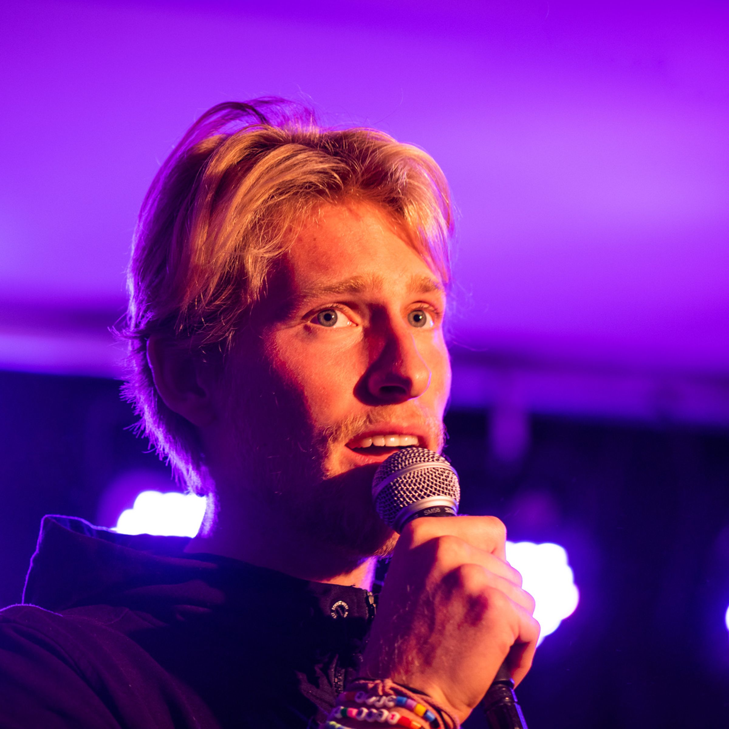 En man sjunger på en scen med fin ljussättning